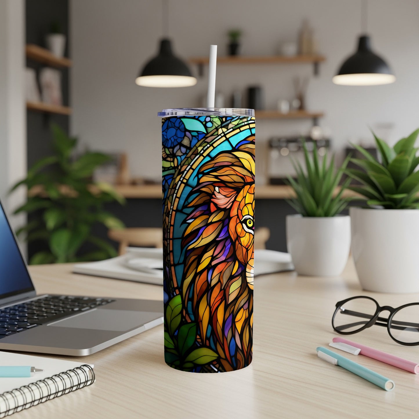 Tall tumbler with a stained-glass lion design on a desk.