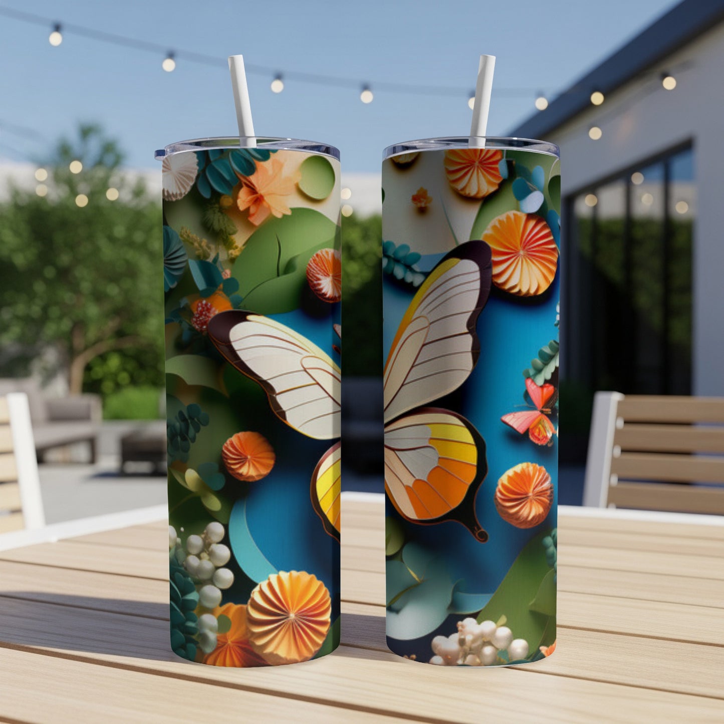 Two tumblers with a colorful butterfly and floral design sit on a table outdoors.