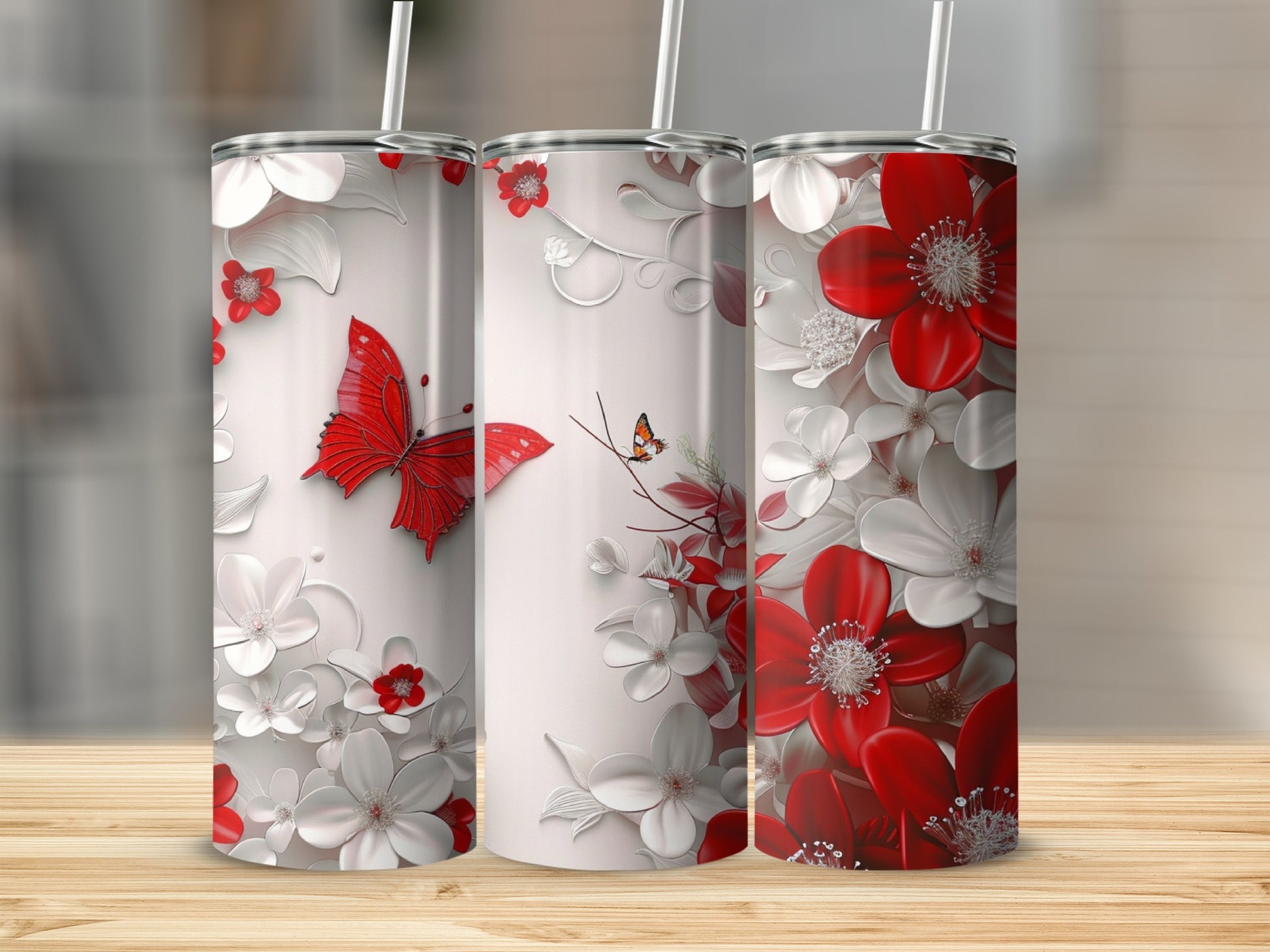 Three tumblers with red butterflies and white and red flowers.
