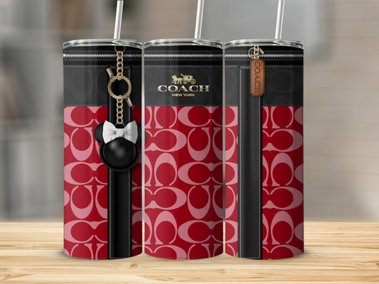 Coach tumbler with red signature C pattern and black accents, featuring charms.