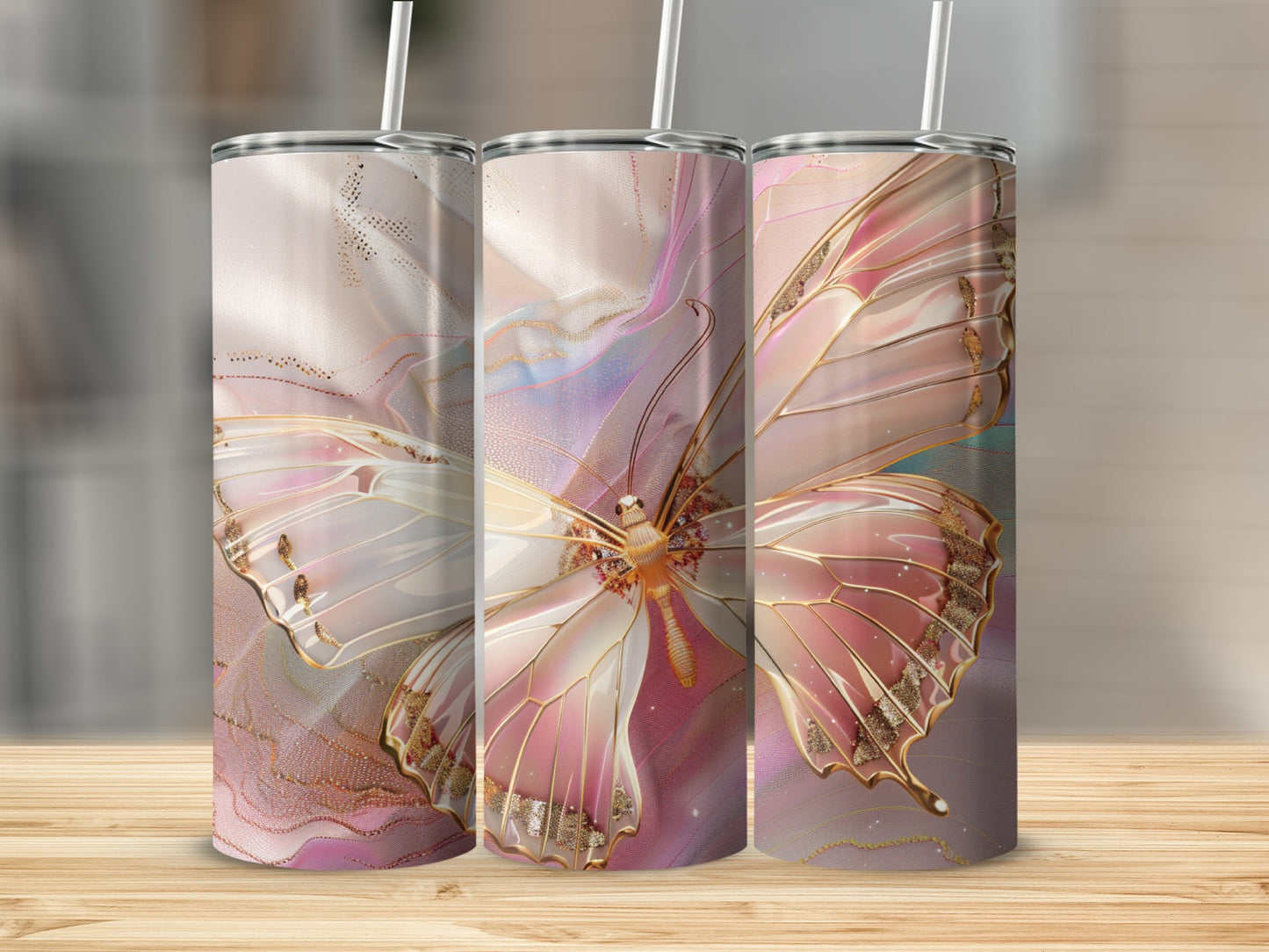Three tall tumblers with iridescent butterfly designs and gold accents.