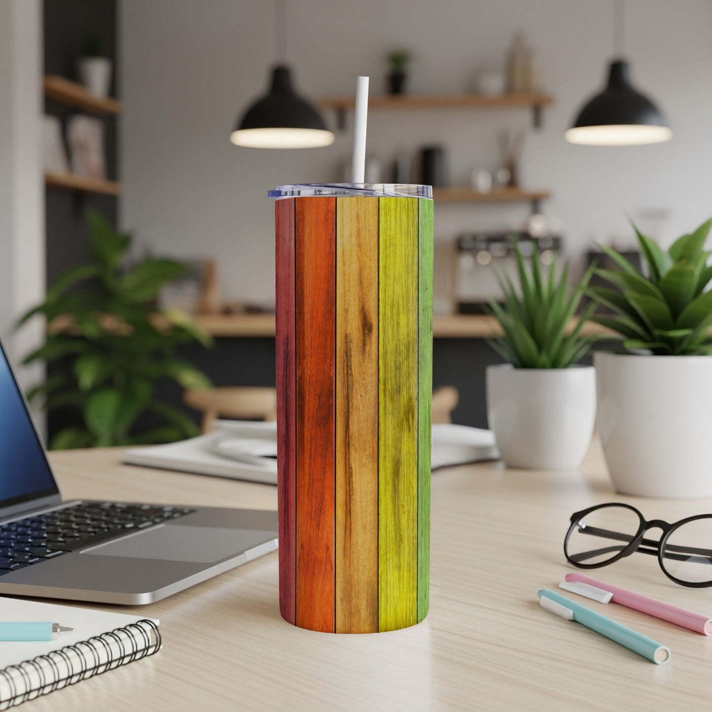 Rainbow wood grain tumbler with white straw on a desk.