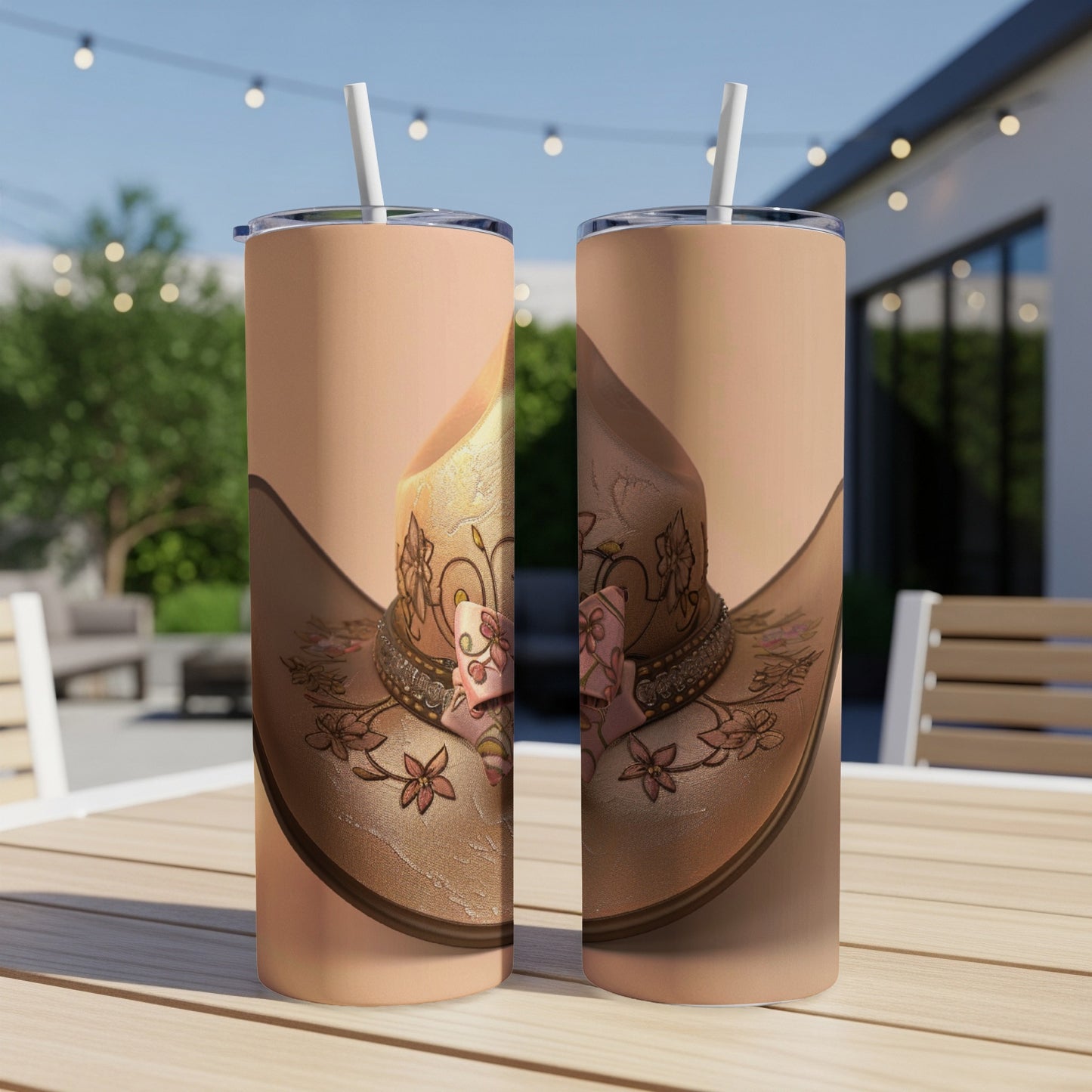 Two cowgirl hats with floral designs on tumblers.