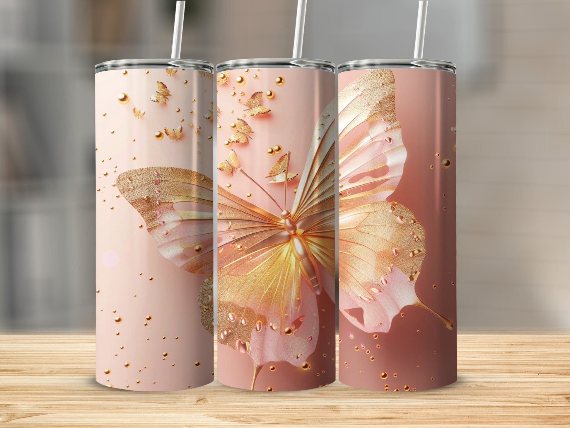 Three pink tumblers with gold butterfly and droplet designs.