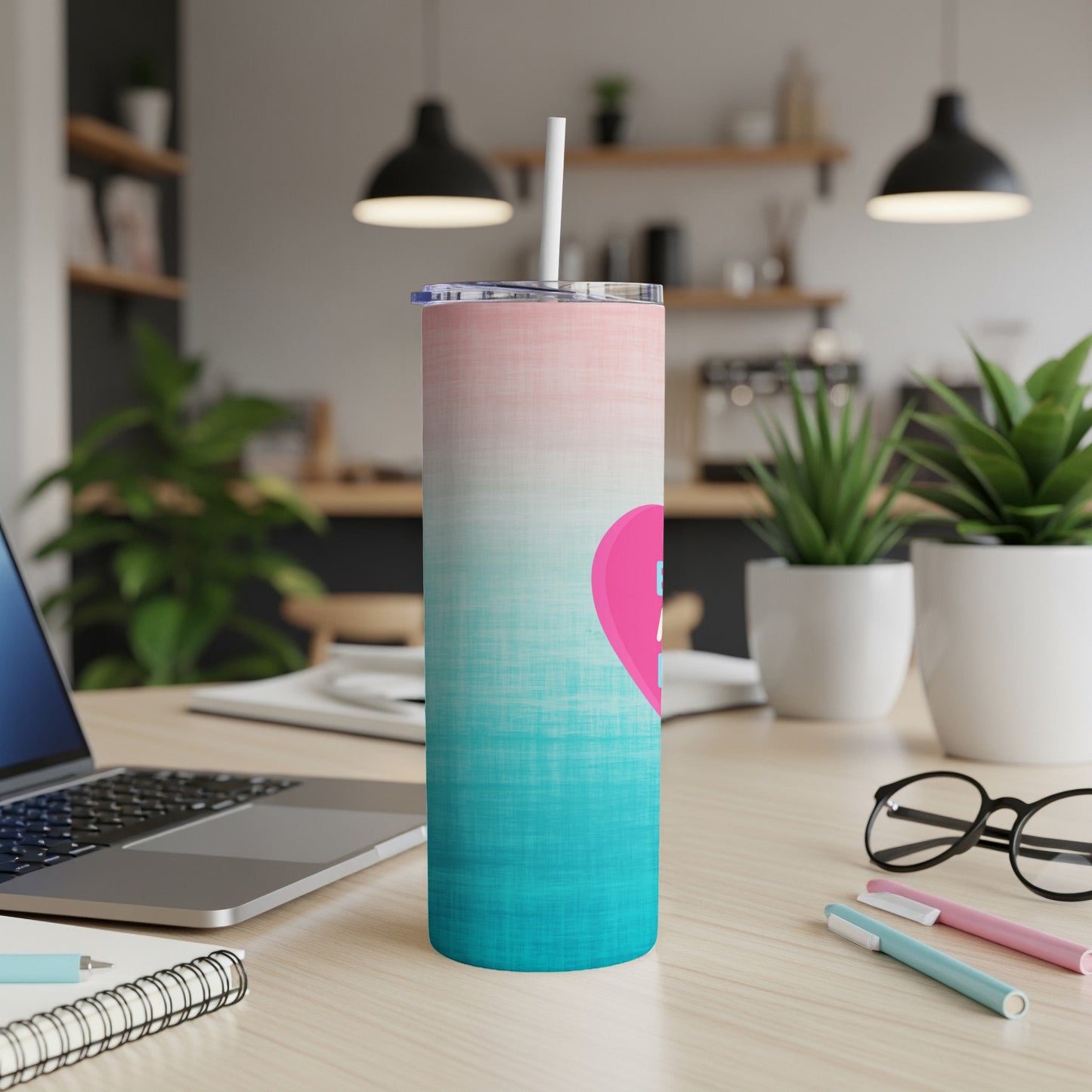 Pink and blue gradient tumbler with a pink heart on a wooden desk.