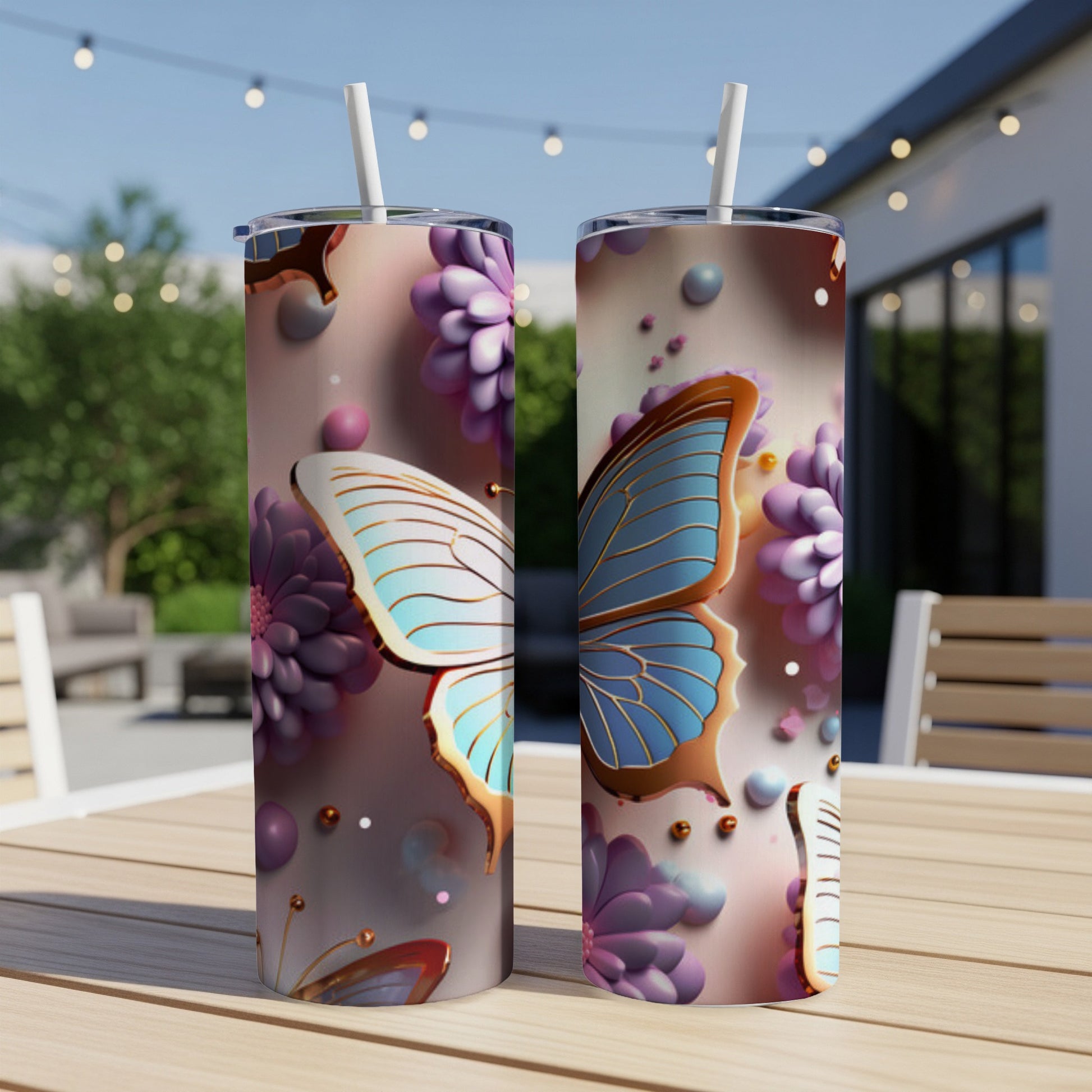 Two tumblers with floral and butterfly designs on a table outdoors.
