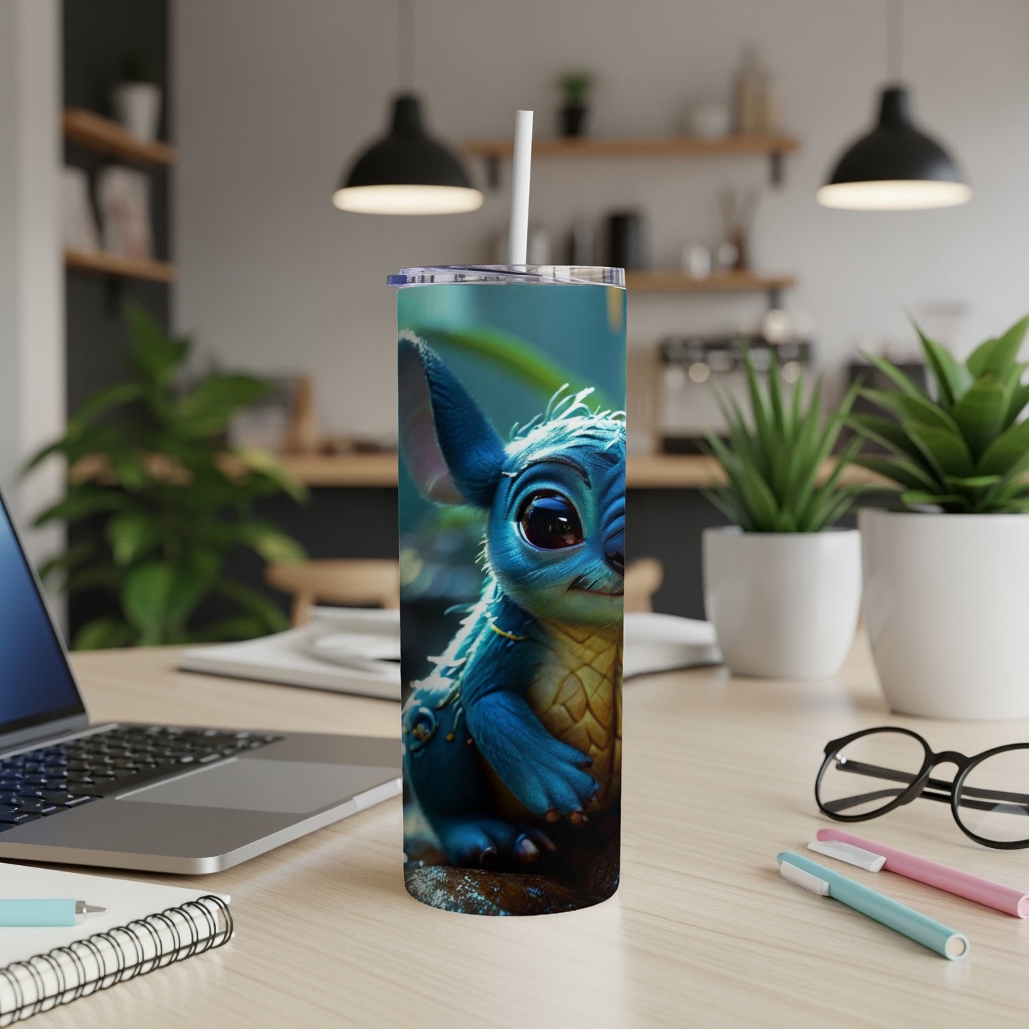 Blue cartoon creature with large ears sits on a wooden surface next to a laptop.