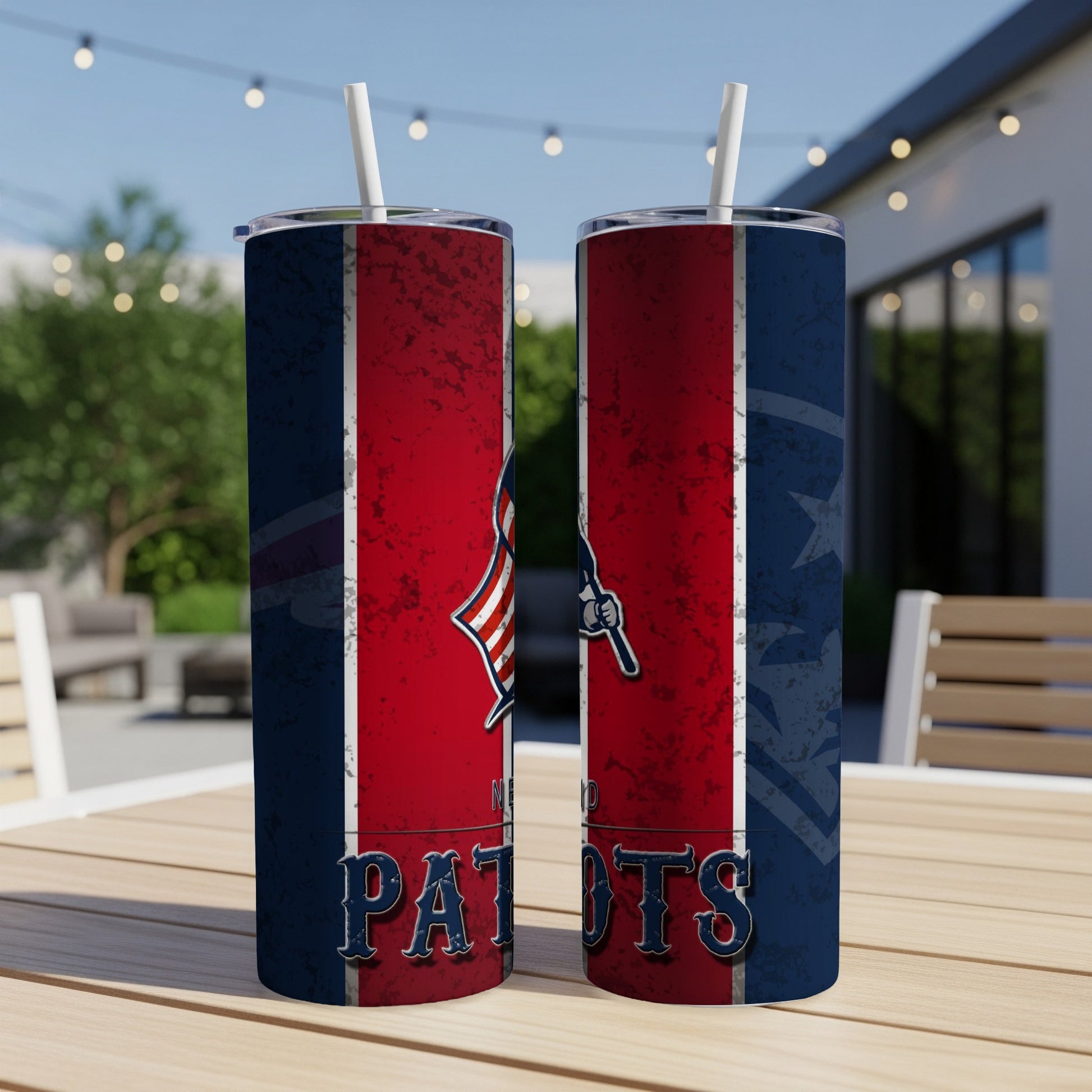 Two New England Patriots tumblers with straws on a wooden table.