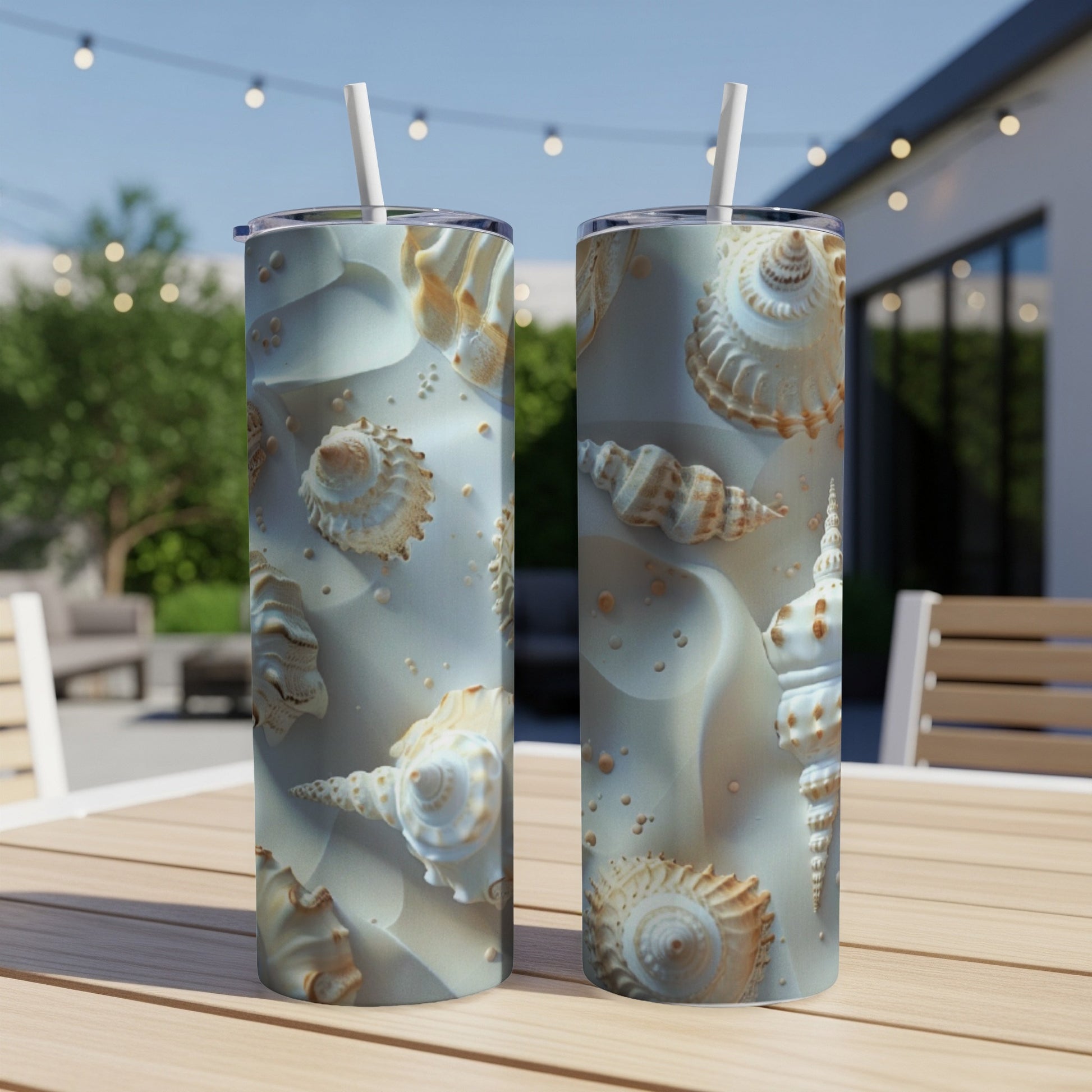 Two tall tumblers with realistic seashell patterns sit on a wooden table outdoors.
