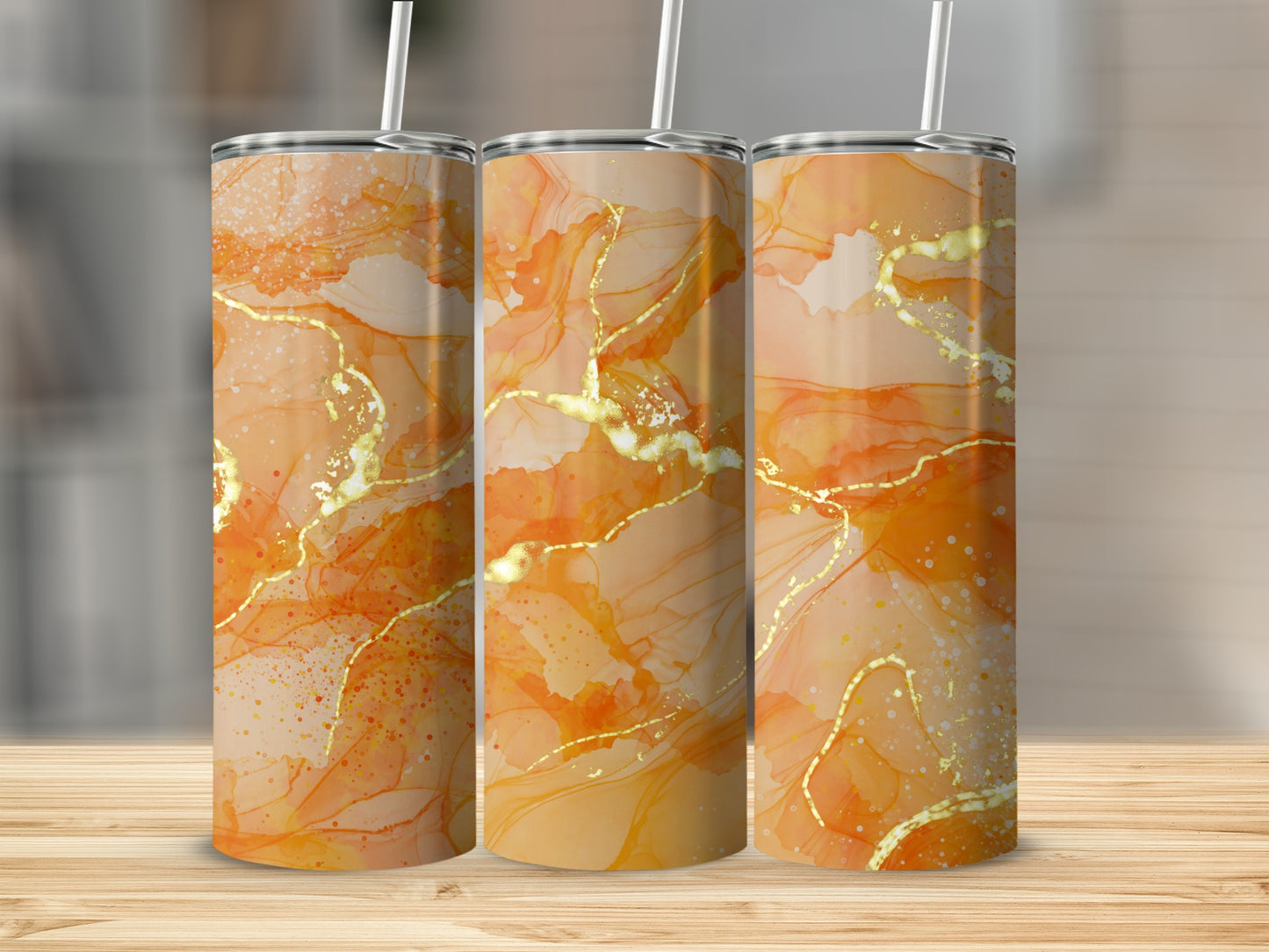 Three tumblers with marbled orange and gold abstract patterns and straws.