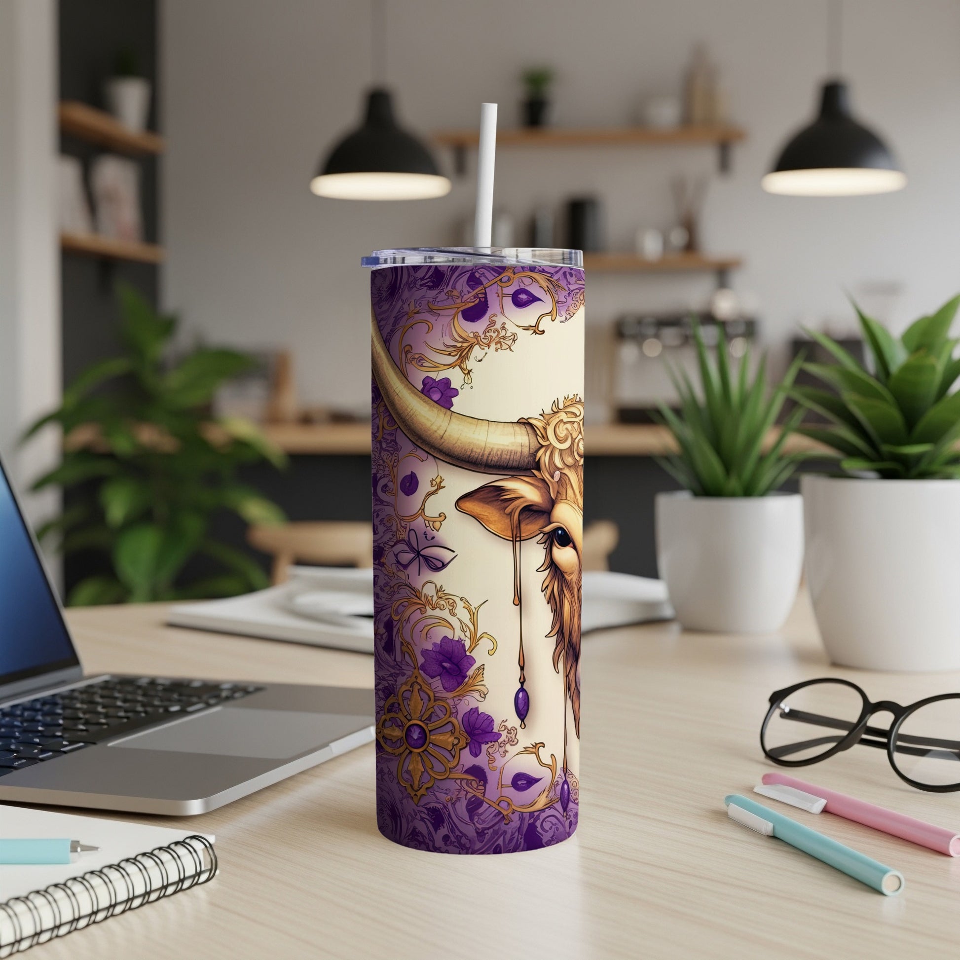 Gold Taurus zodiac symbol on a purple patterned tumbler with a straw.