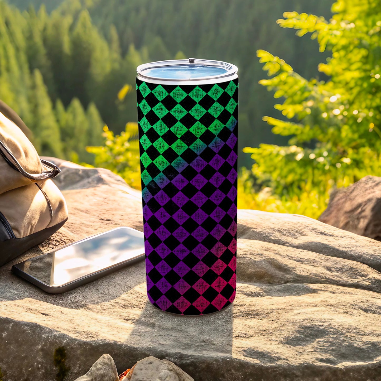 Tall tumbler with green and purple checkered pattern on outdoor rock surface.