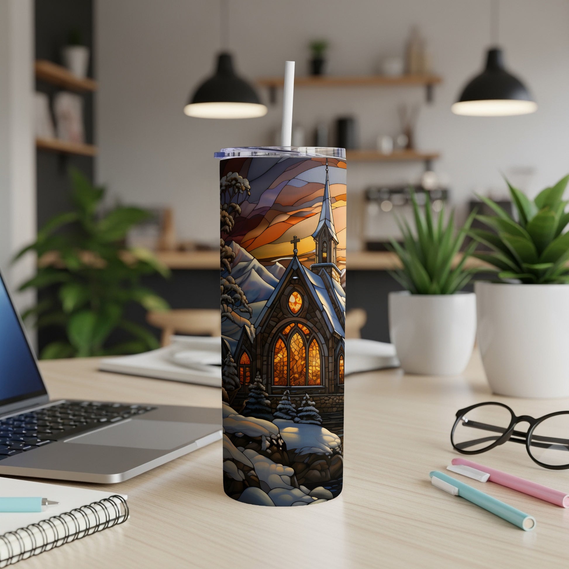 Winter stained glass church tumbler with straw on desk.