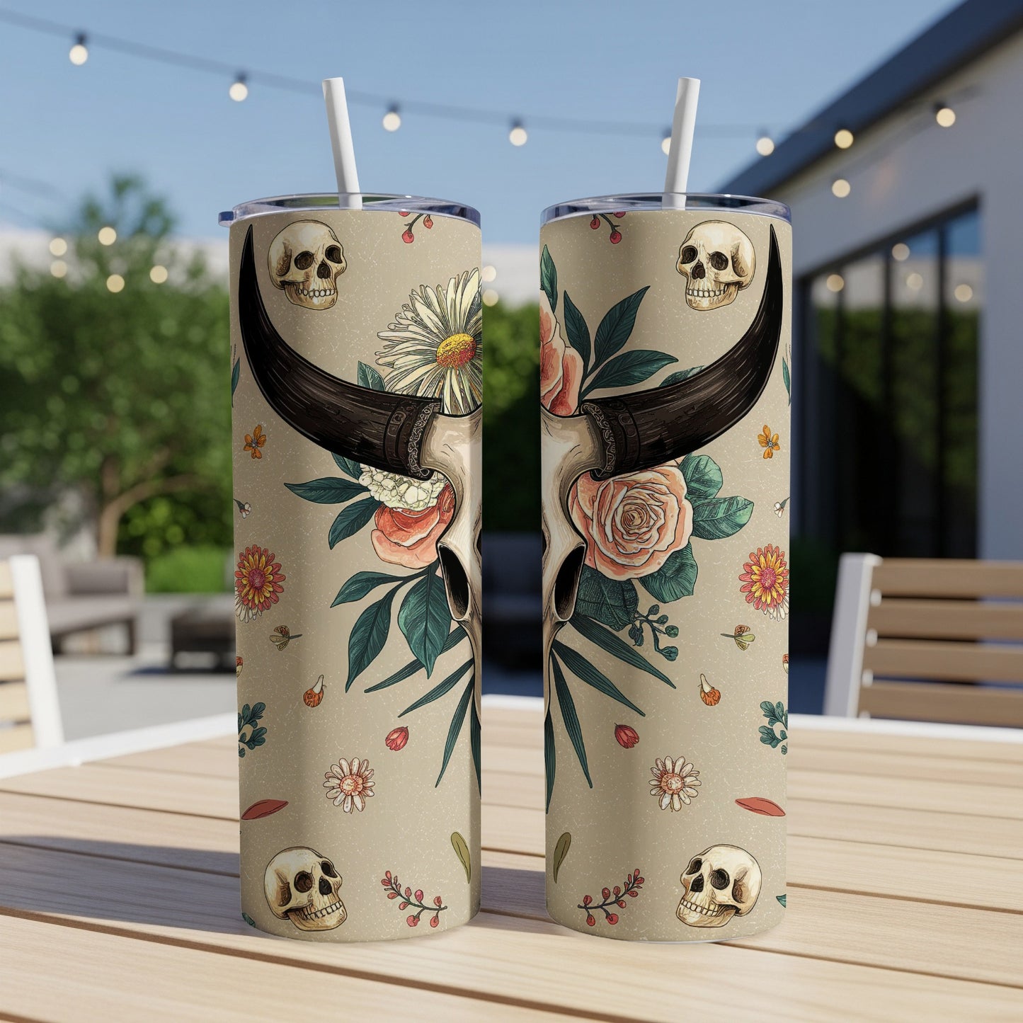 Two tan tumblers with skull and floral designs on a table.