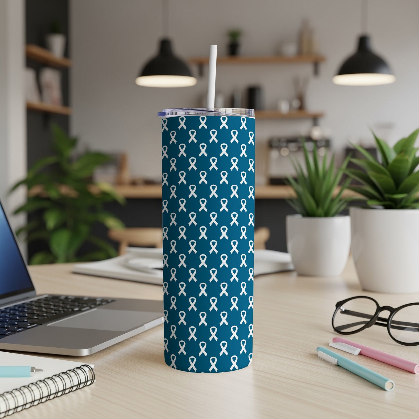 Dark blue tumbler with repeating white ribbon pattern and visible straw.