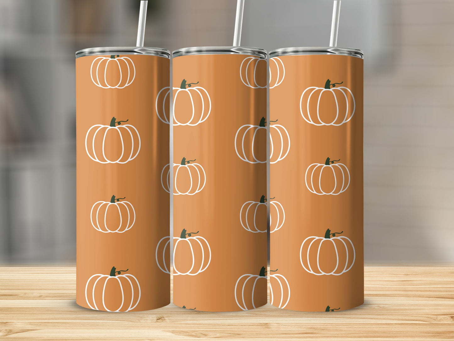 Orange tumbler with white pumpkin pattern.