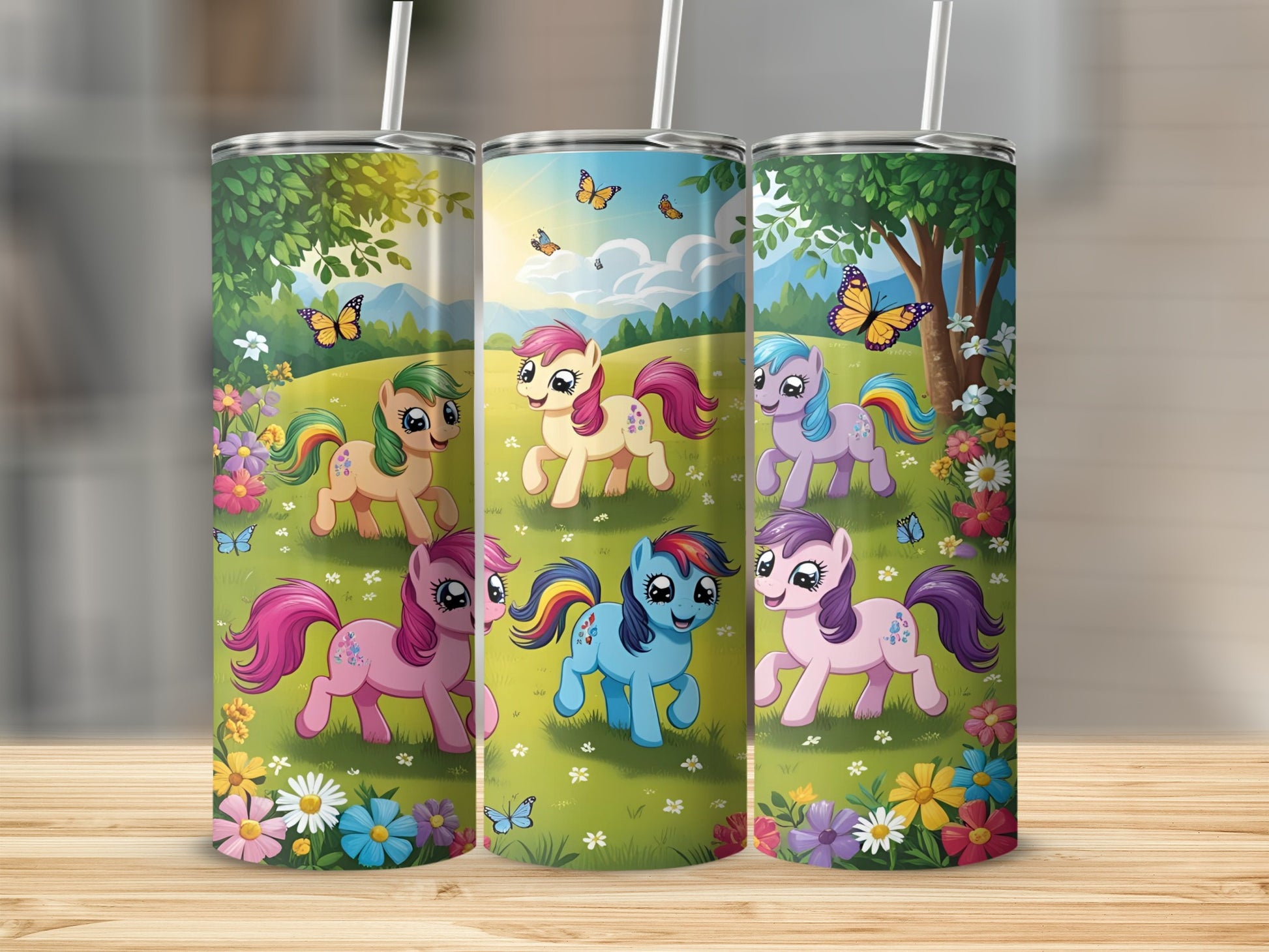 Three colorful tumblers featuring cartoon ponies and butterflies in a grassy meadow.