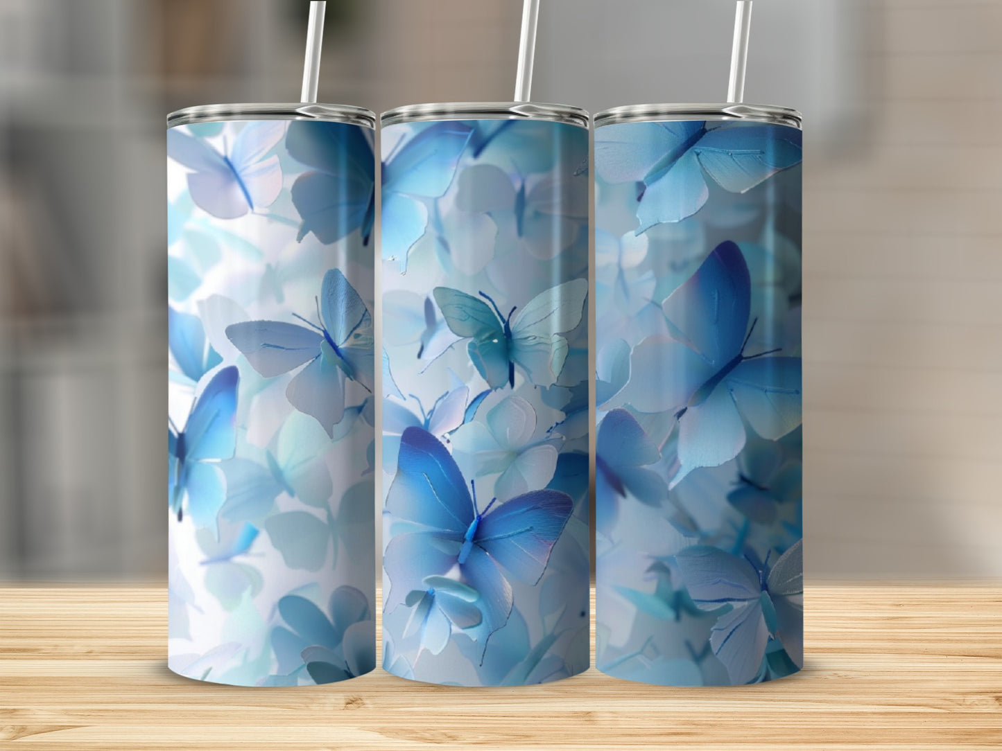 Three tumblers adorned with a pattern of blue butterflies and floral elements.
