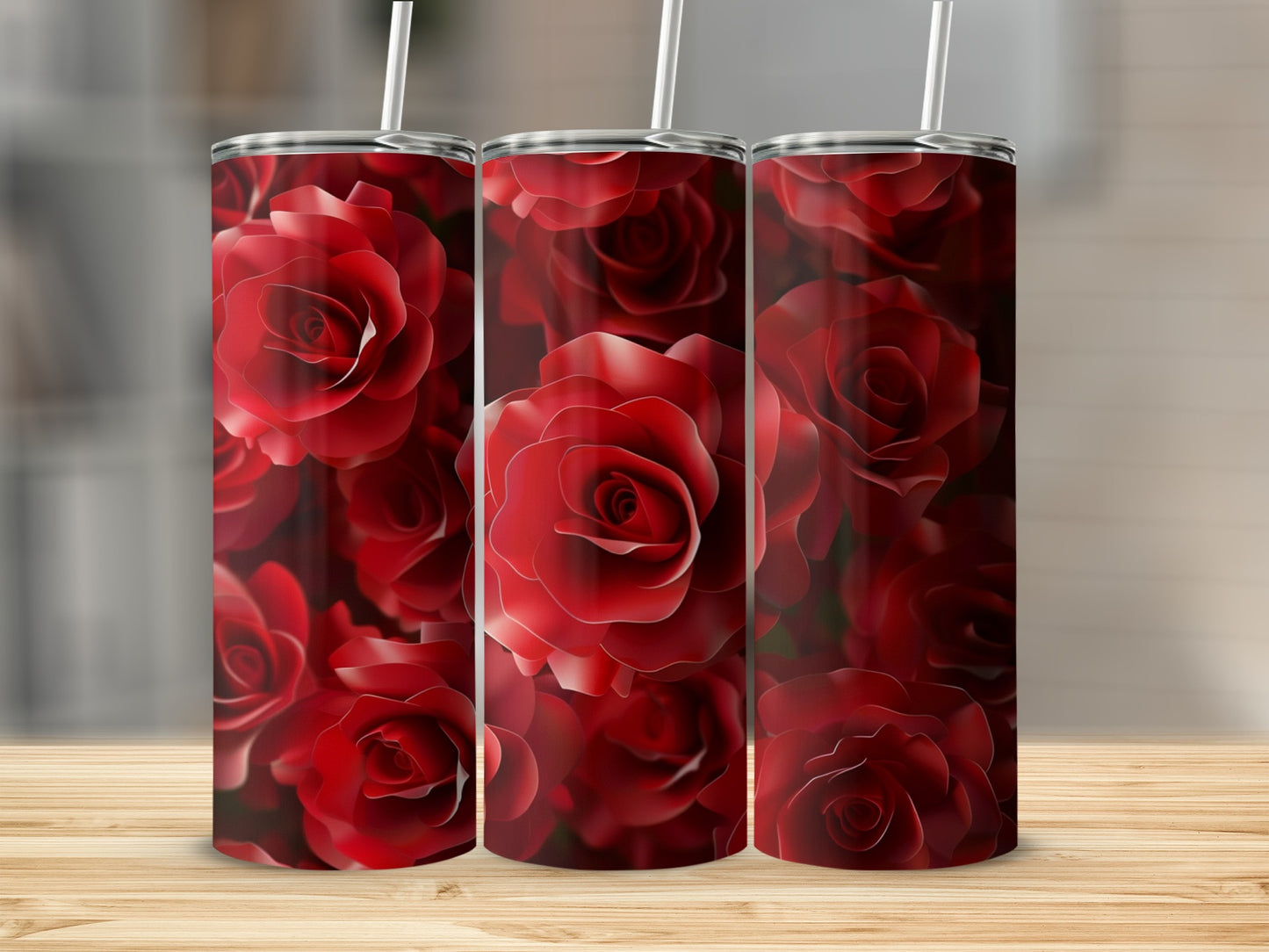 Three tumblers with a repeating pattern of deep red roses on a wooden surface.
