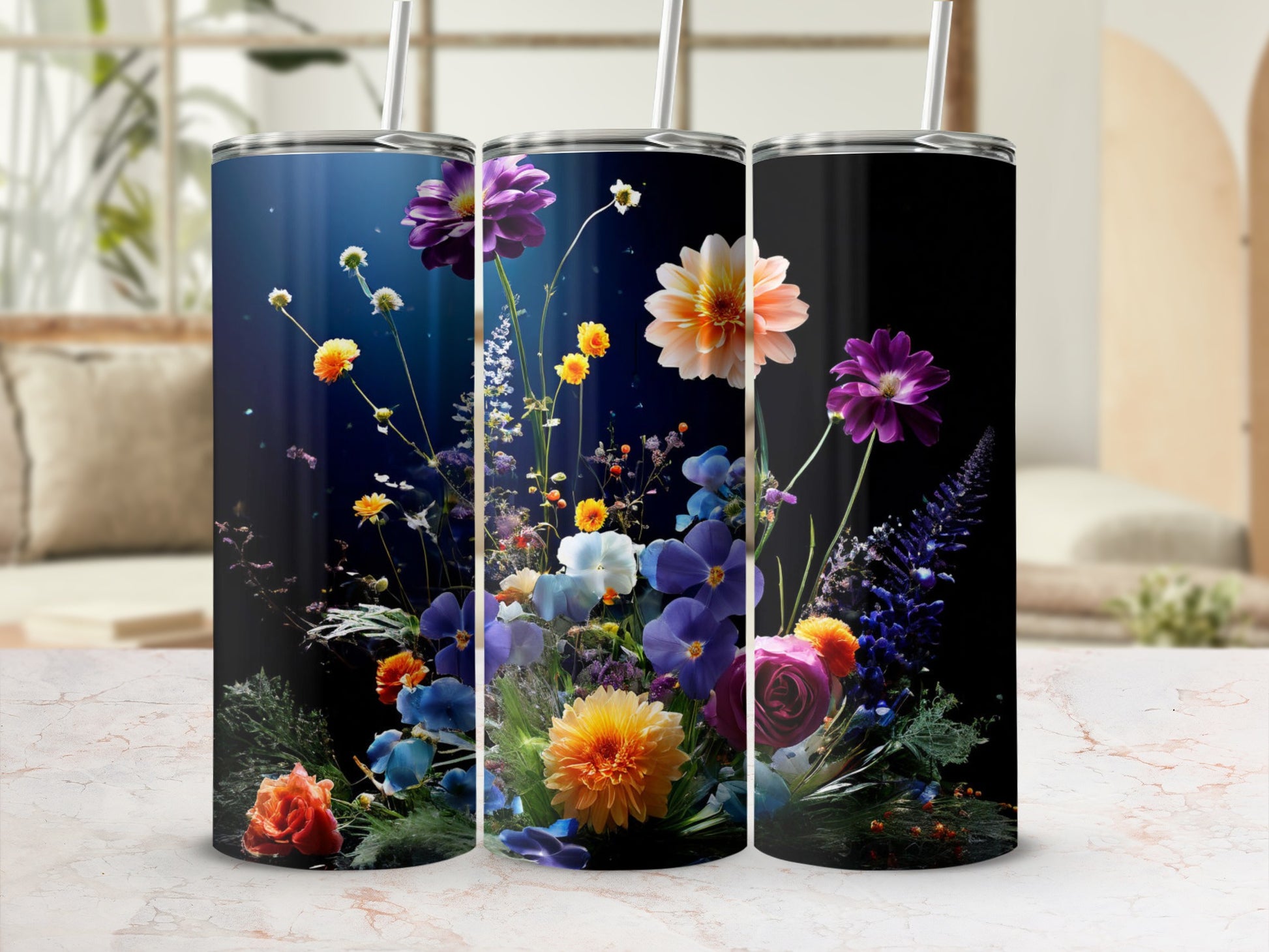 Floral design on three tumblers with straws, against a blurred background.