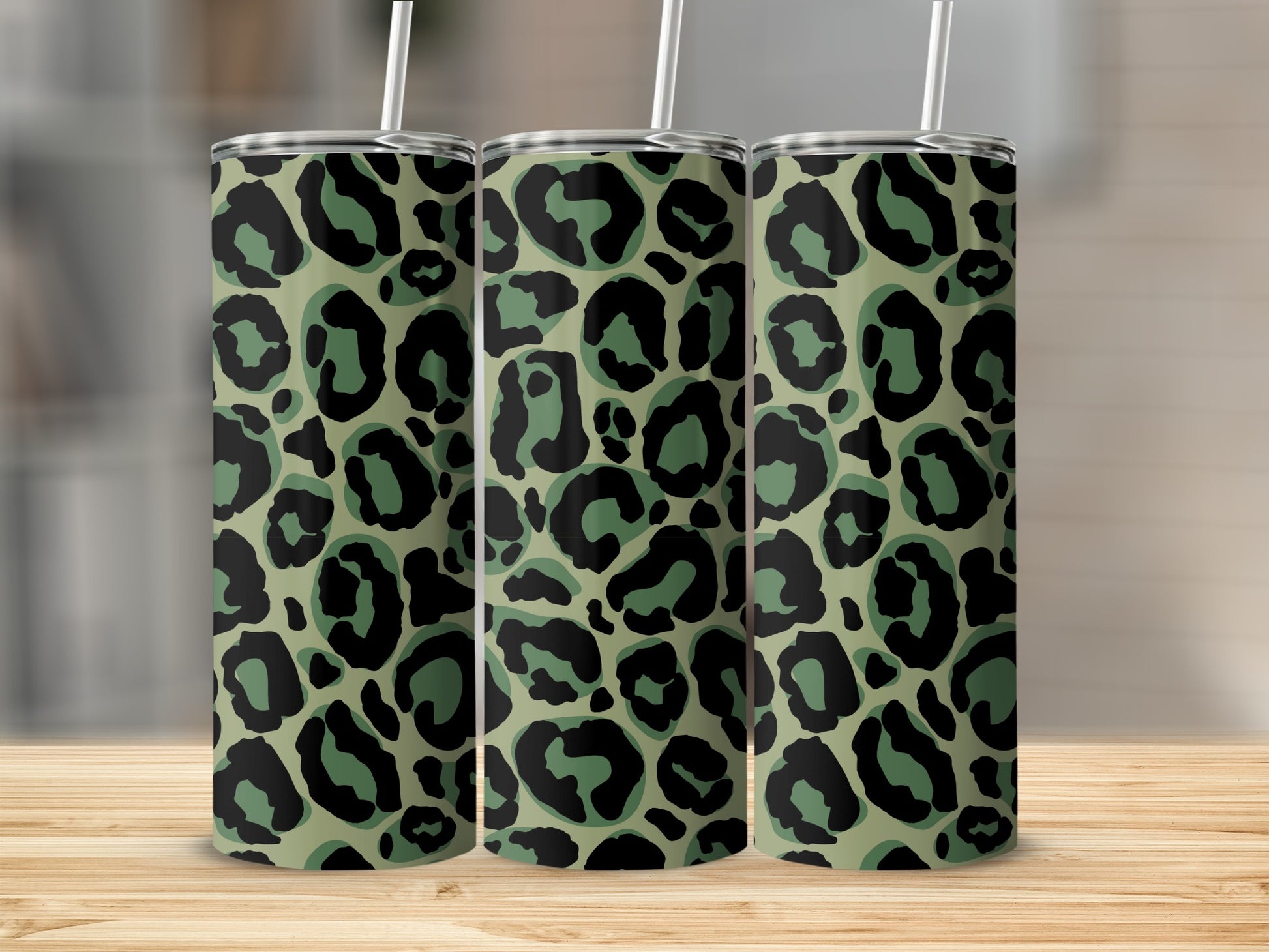 Three tumblers with a camouflage leopard print pattern on a wooden surface.