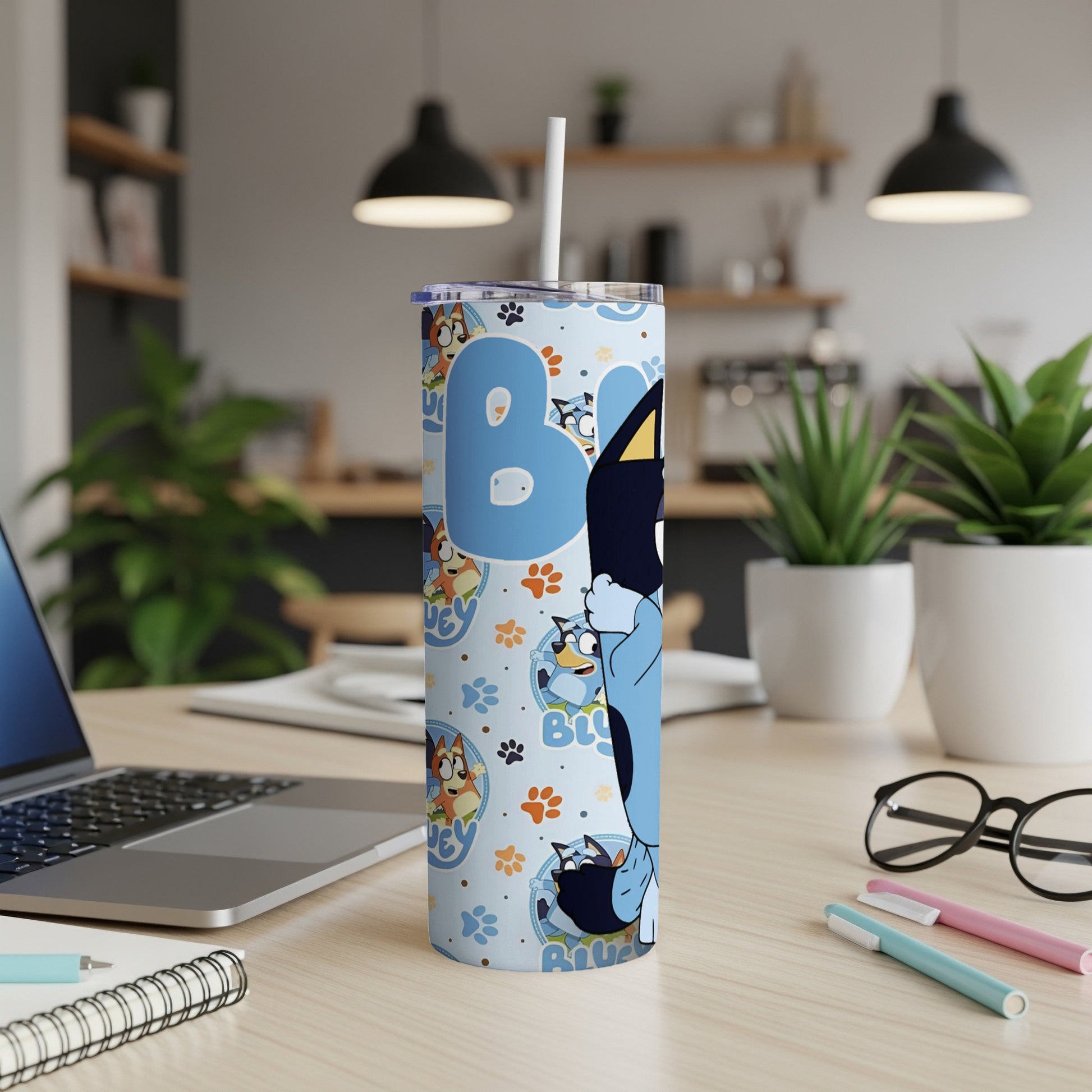 Bluey characters on a tall blue tumbler with paw prints and bone pattern.