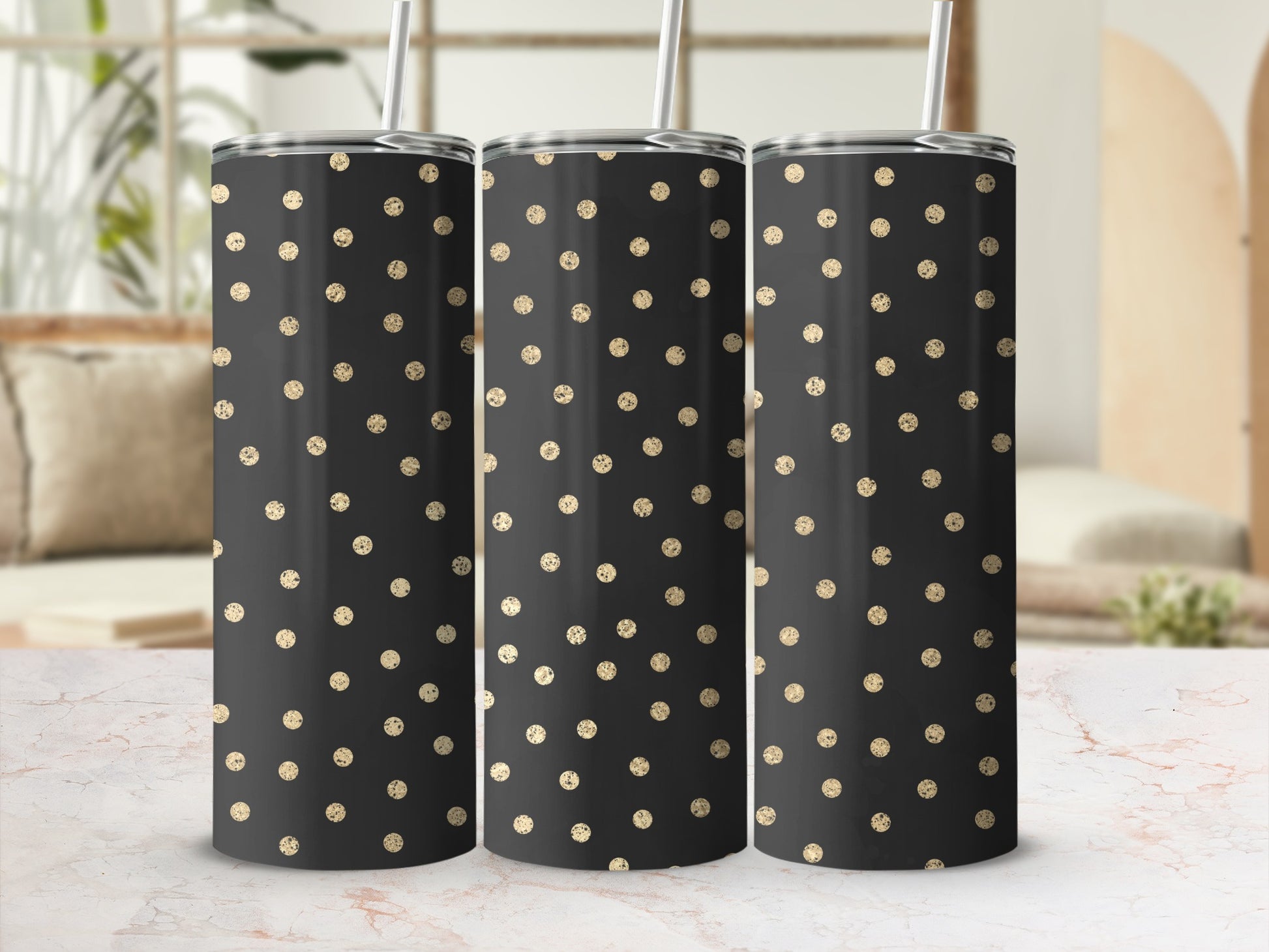 Three black tumblers with gold glitter polka dots and straws stand side by side.