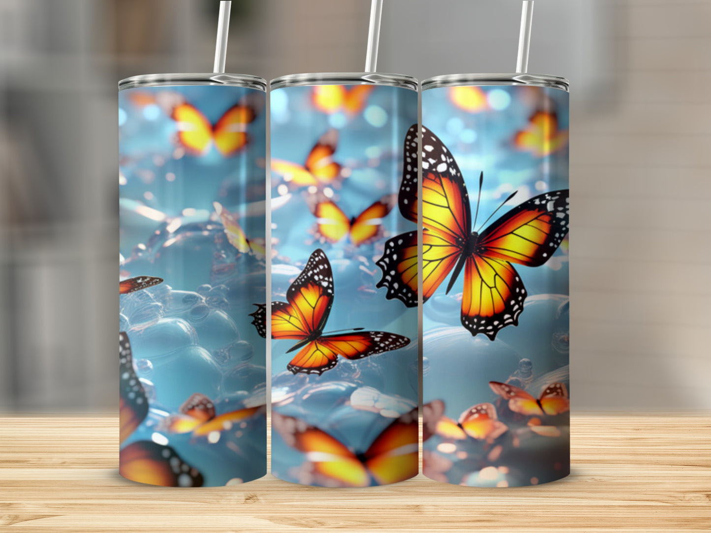 Three tumblers with colorful butterflies against a blurred blue background.