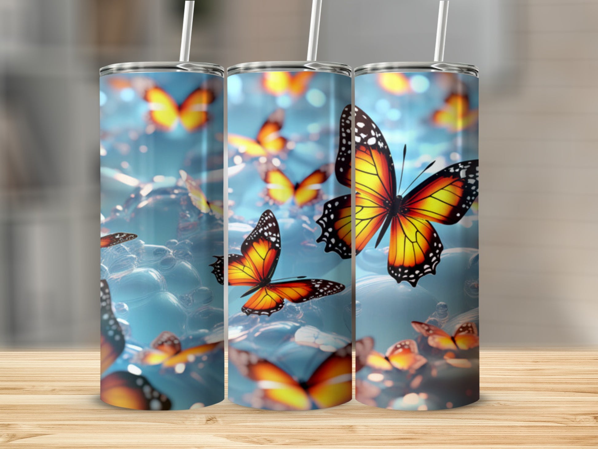 Three tumblers with colorful butterflies against a blurred blue background.