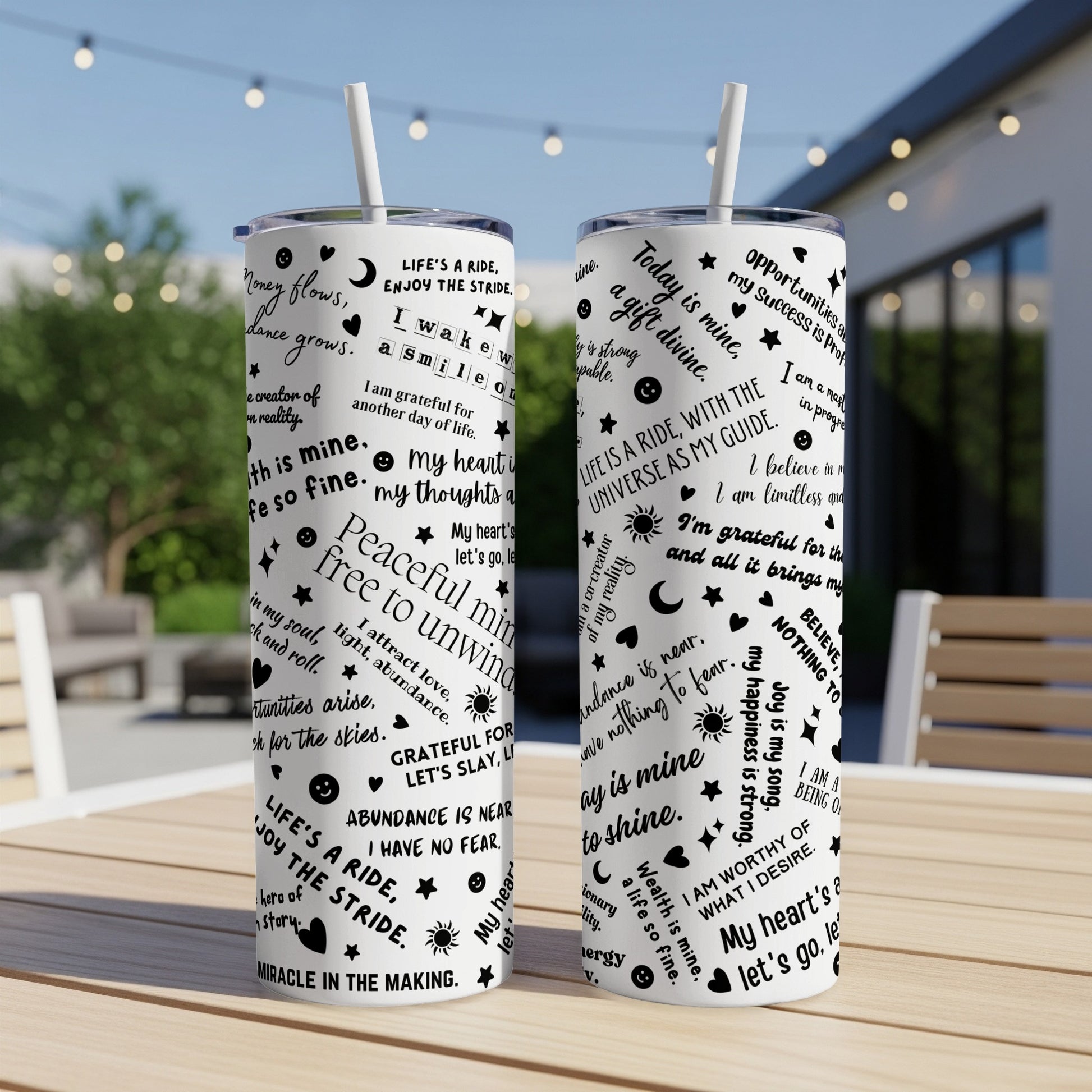 Tumblers with motivational text designs on a wooden table.