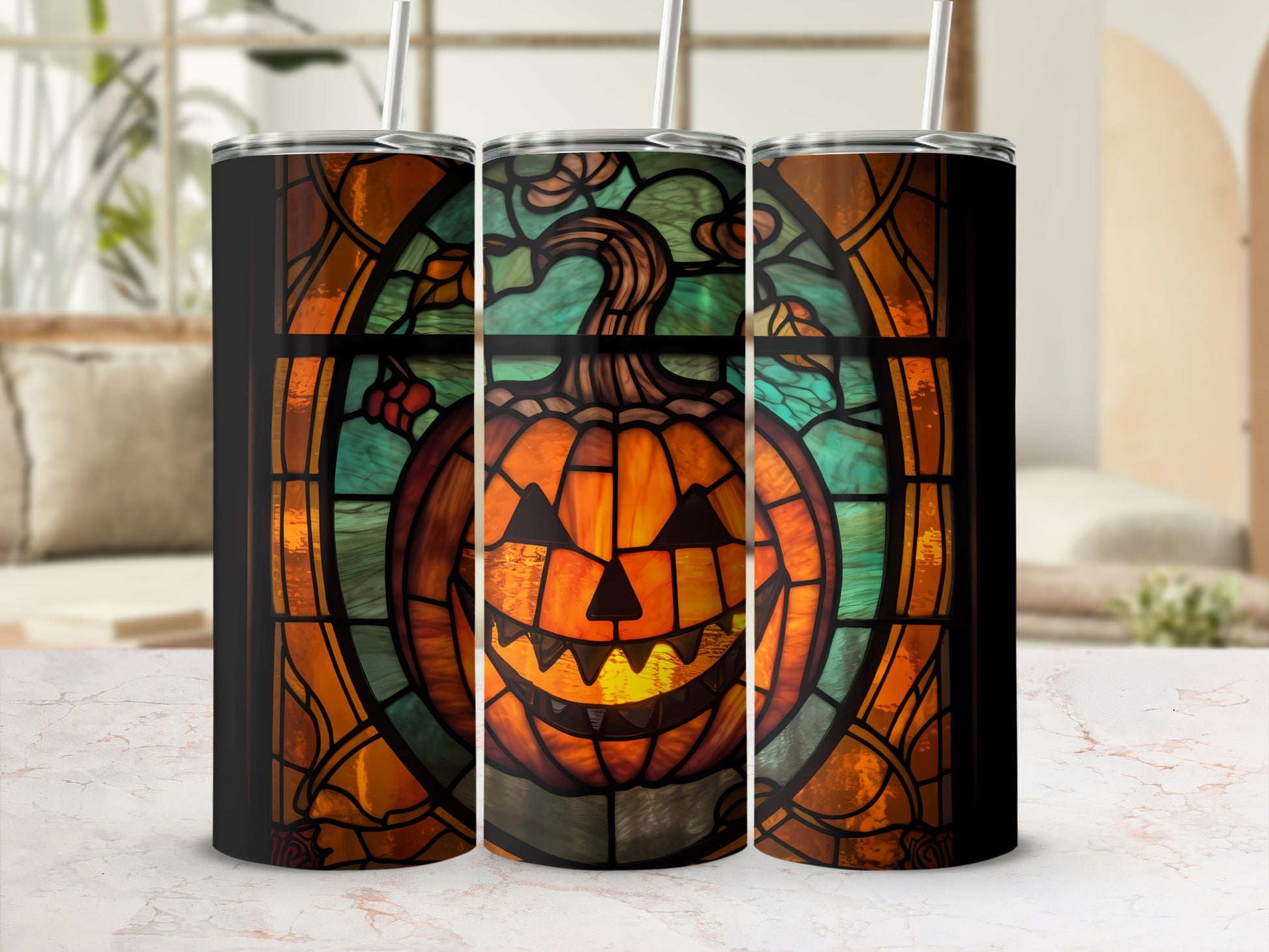 Three tumblers with stained glass pumpkin design in a window frame.