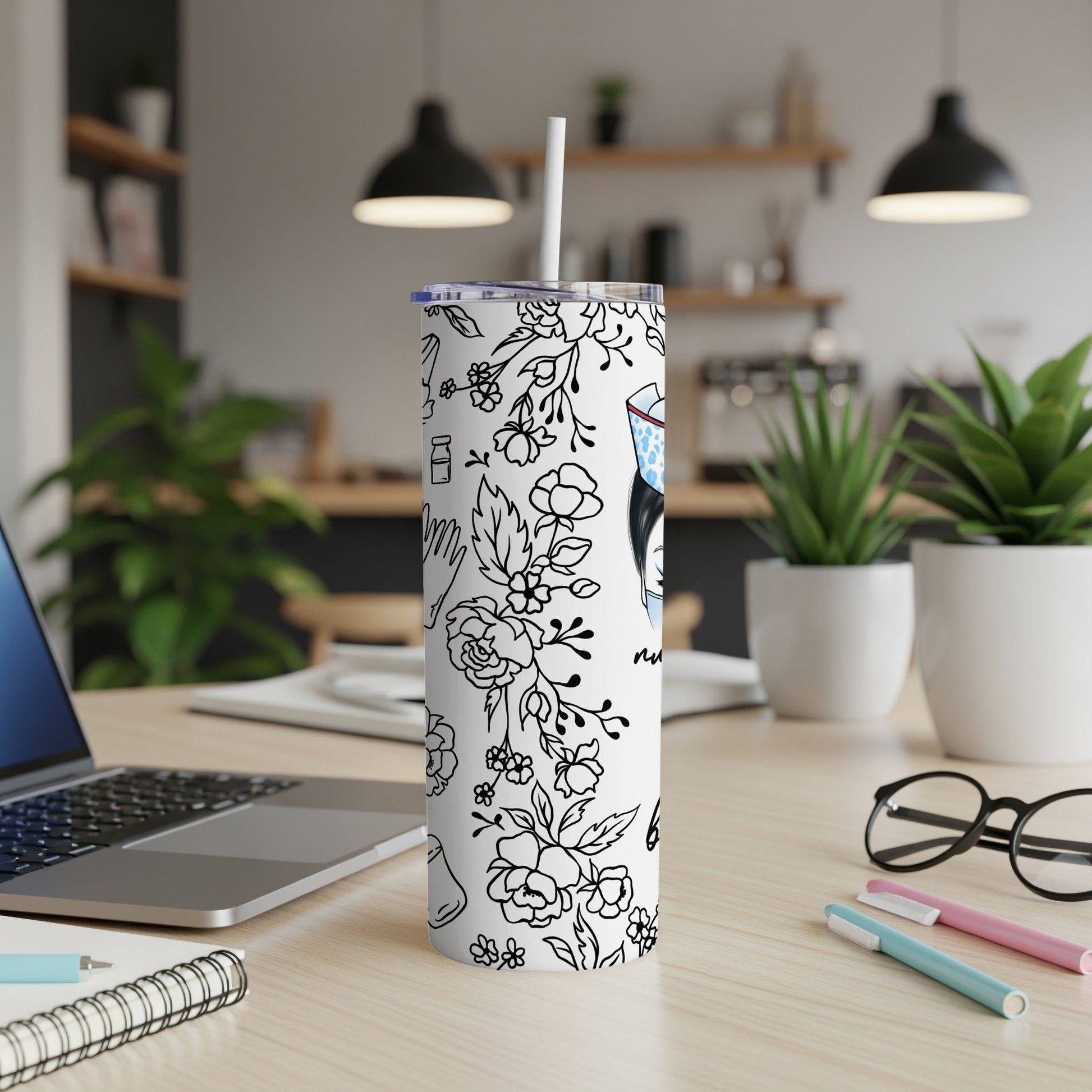 White tumbler with black floral and medical illustration, white straw.