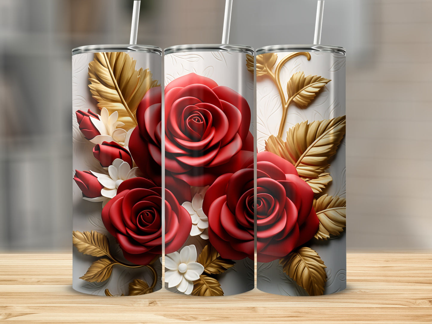 Three tumblers with embossed red roses and gold leaves on a wooden surface.