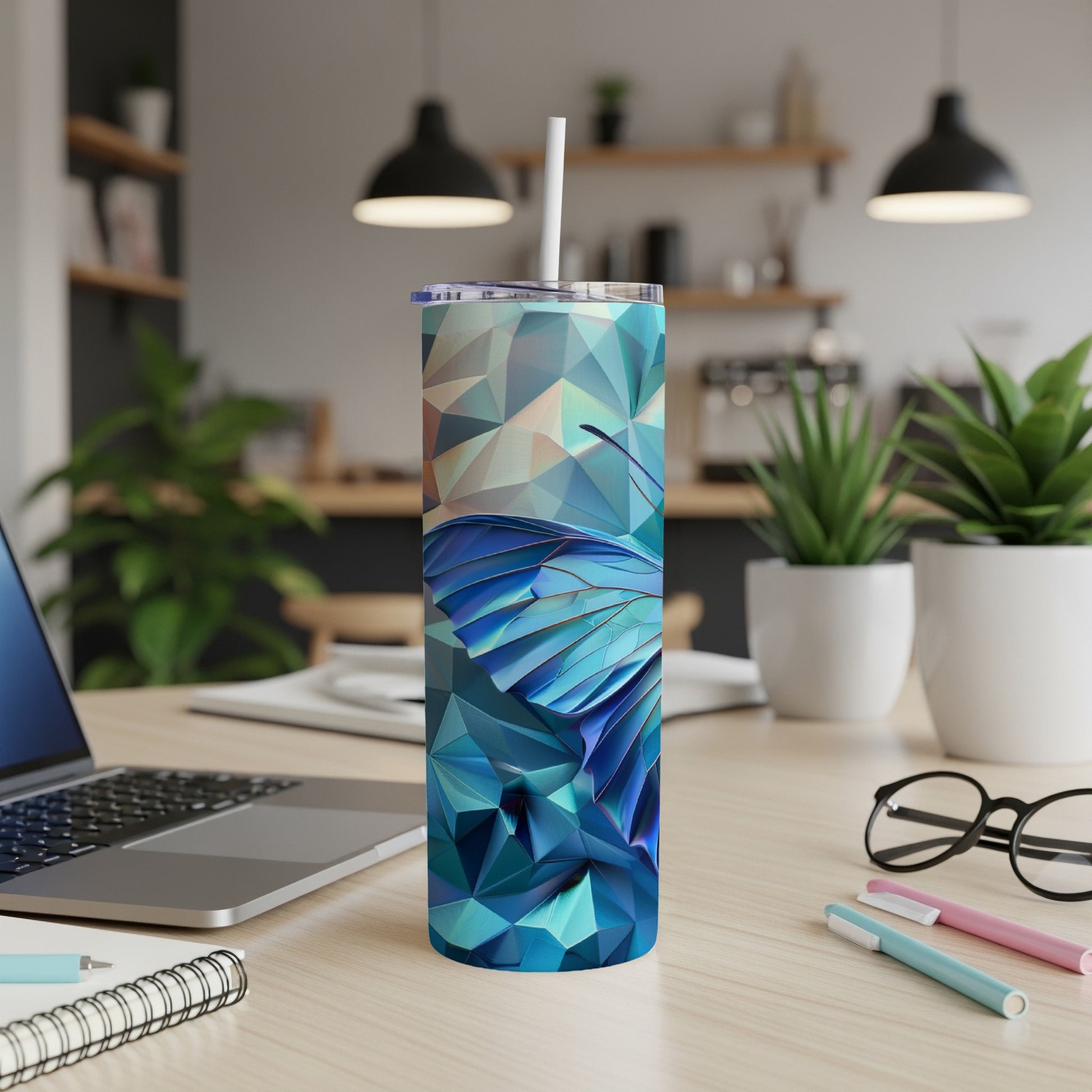 Tumbler with blue butterfly wings design on a desk.