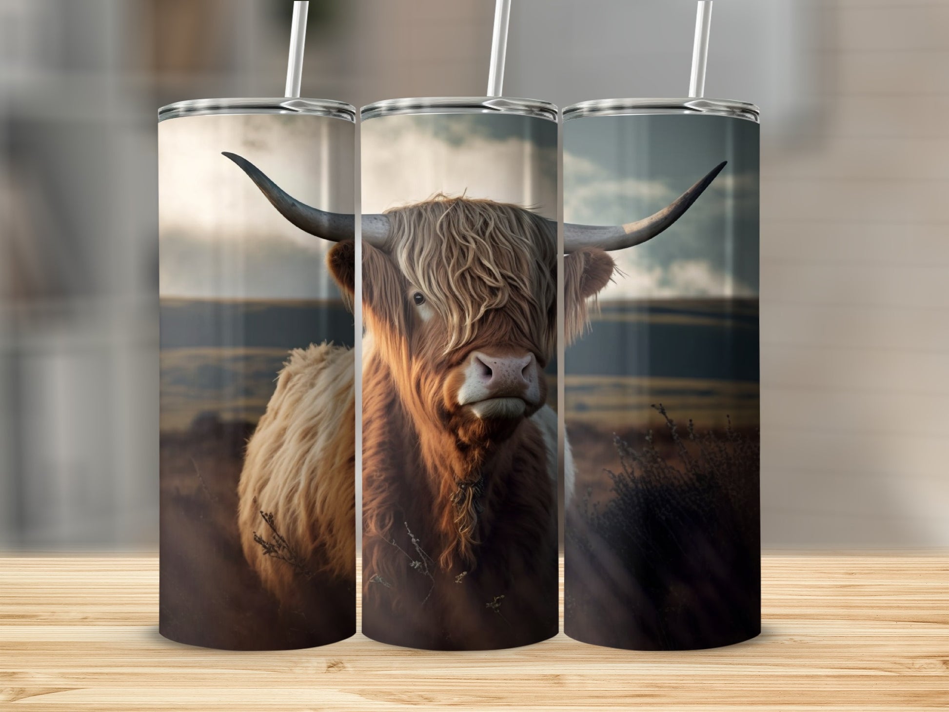 Highland cow with long horns on a tumbler, displayed on a wooden surface.