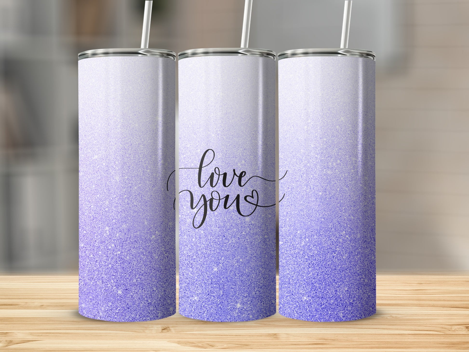 Three glittery purple tumblers with "love you" text on the middle one.