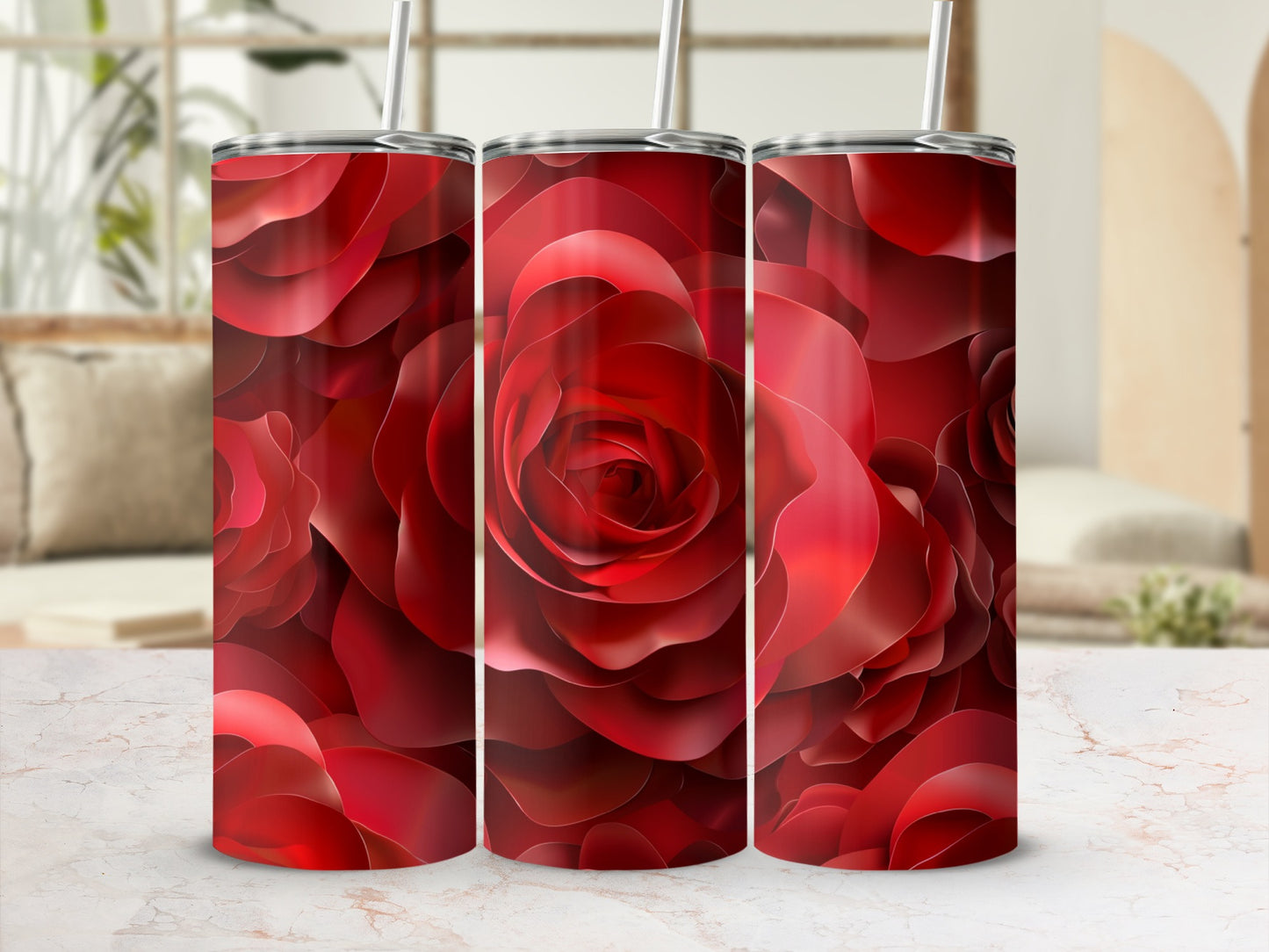 Three red rose patterned tumblers with straws on a marble surface.