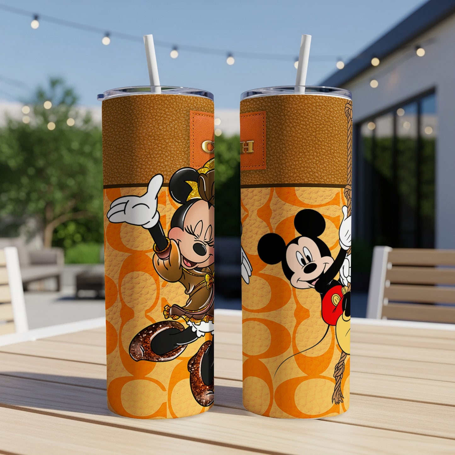 Two tumblers featuring Minnie Mouse and Mickey Mouse with Coach branding on a table.