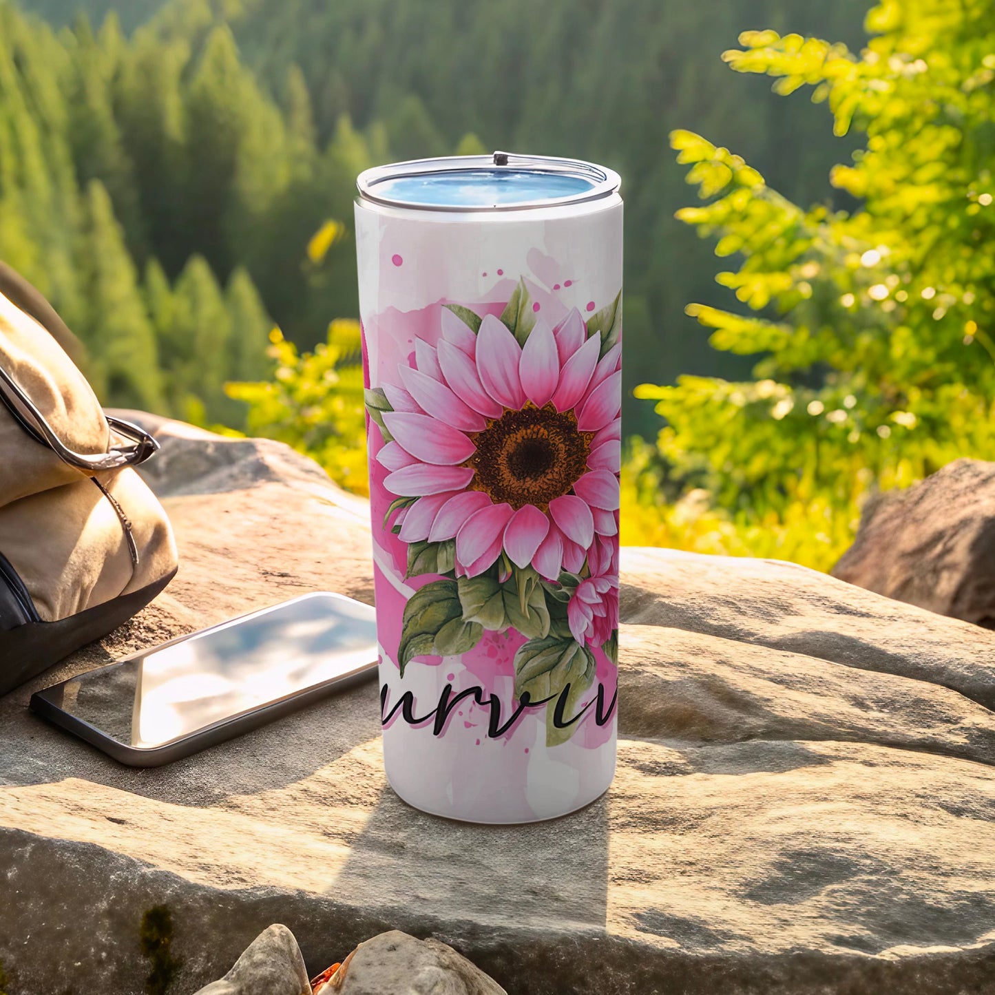 Pink floral tumbler with "survivor" text on a rock with a backpack and phone.
