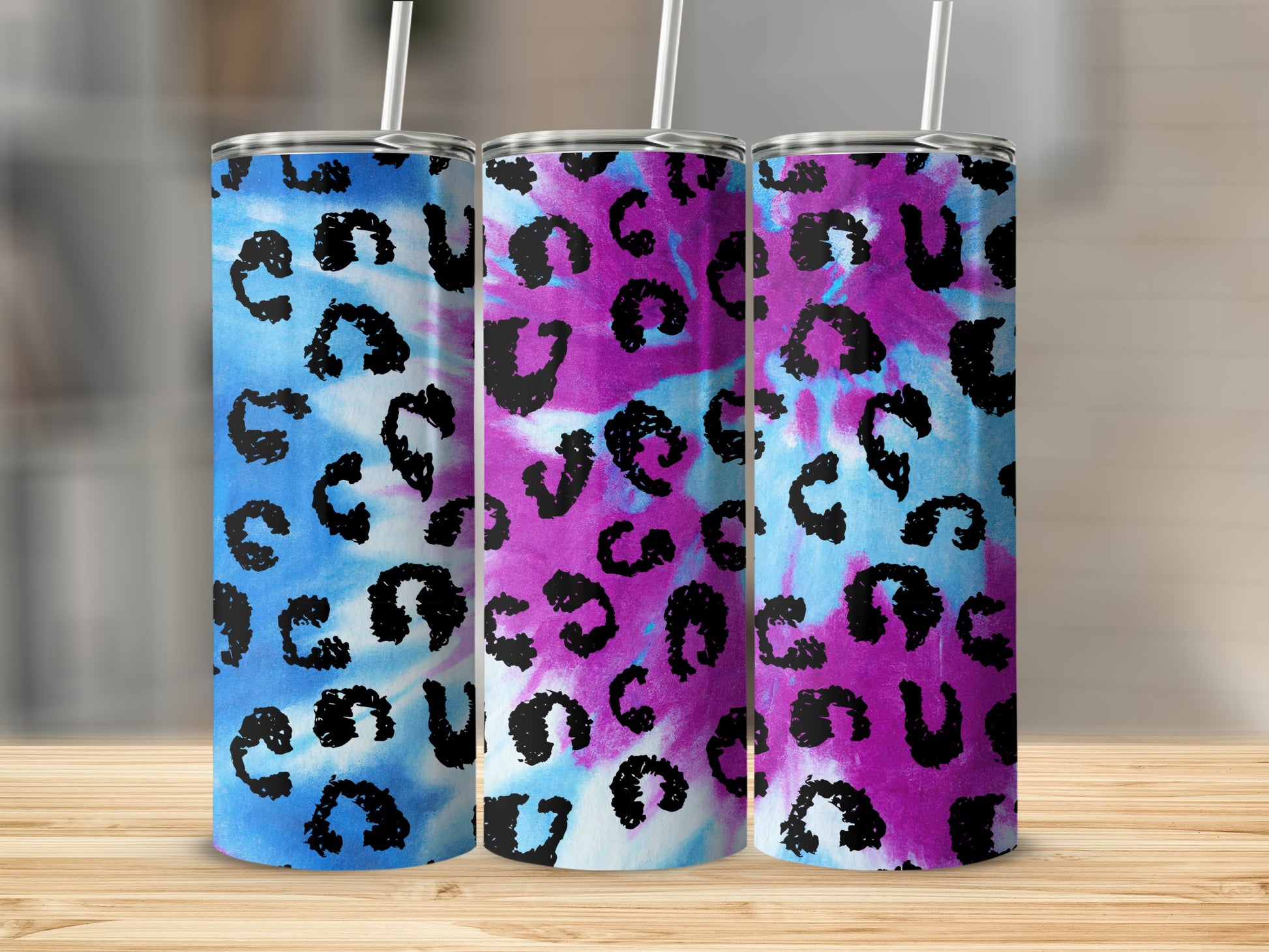 Three tumblers with blue, pink, and purple tie-dye and black leopard print.
