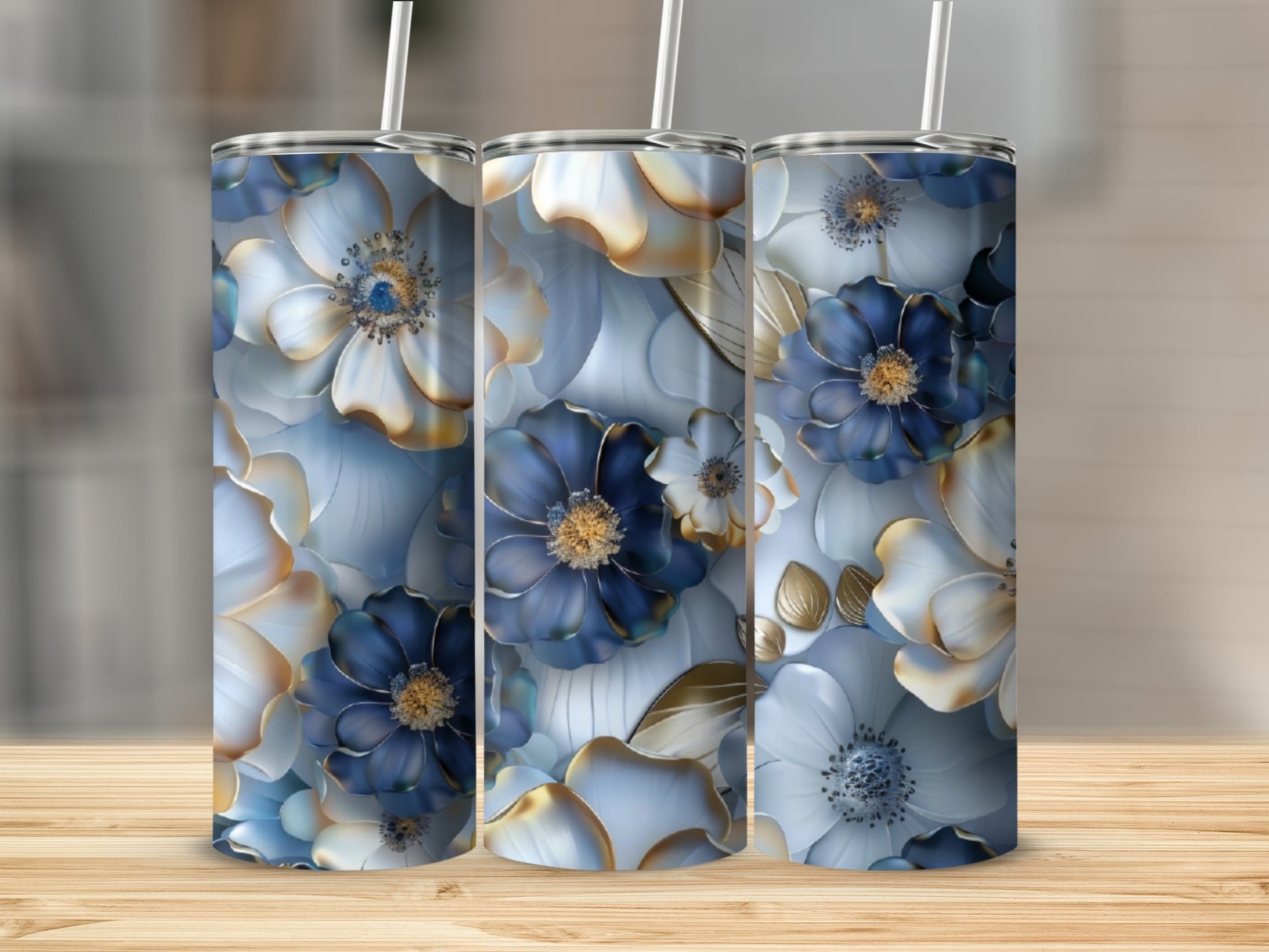 Three tumblers with blue and gold floral designs sit on a wooden surface.