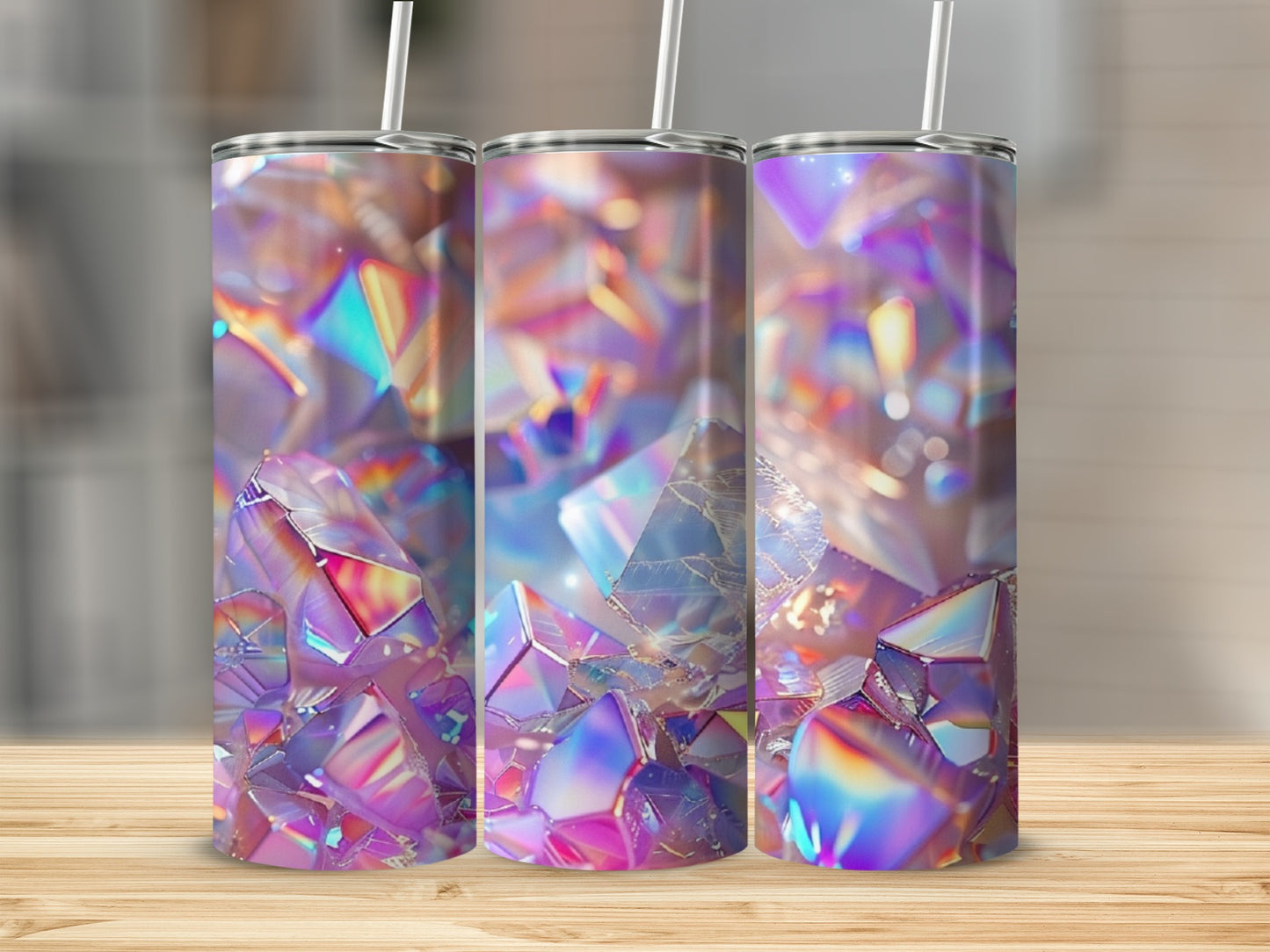 Three tumblers with iridescent crystal designs stand on a wooden surface.