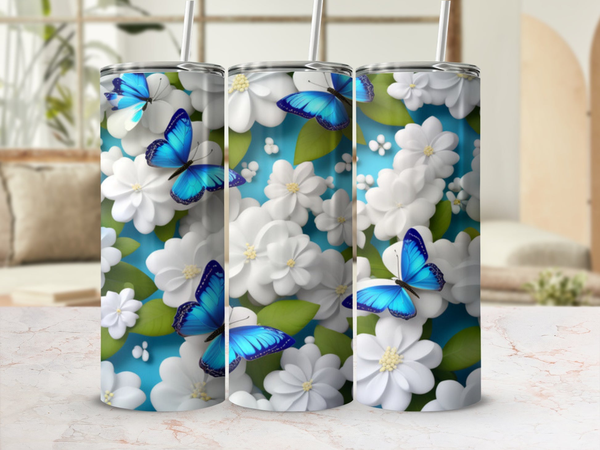 Three tumblers with blue butterflies and white flowers against a blue background.