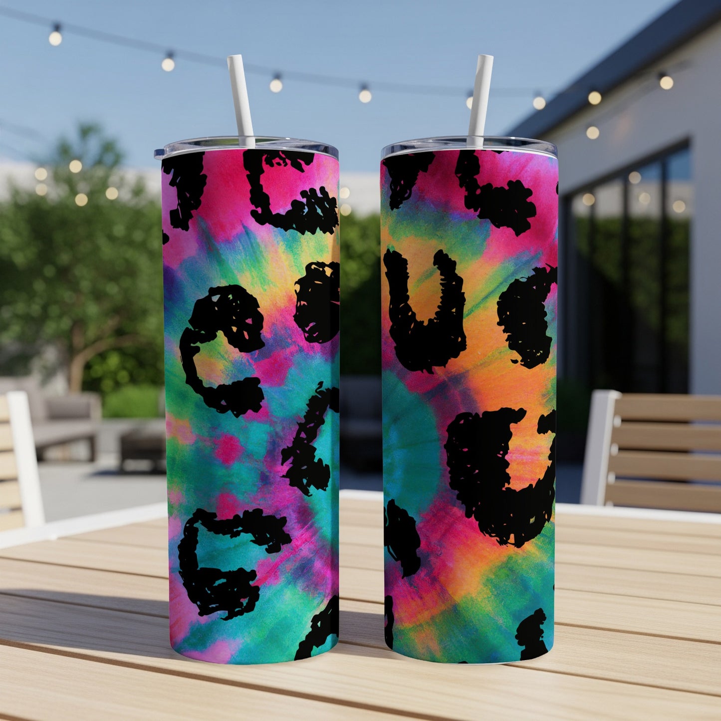 Two tumblers with tie-dye and black leopard print patterns sit on a table.