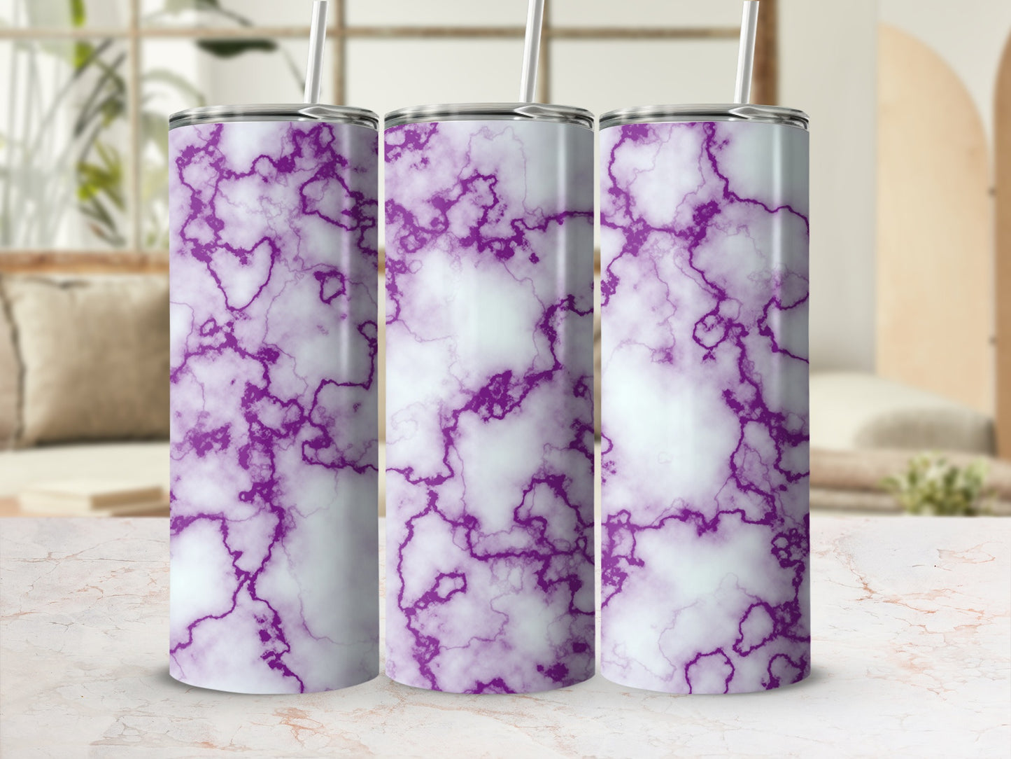 Three purple and white marble print tumblers with straws on a counter.
