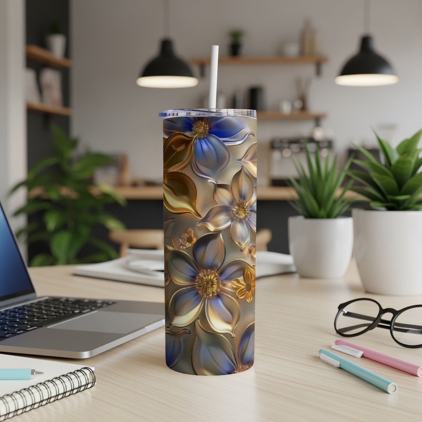 Silver and blue floral pattern on a tall, insulated tumbler with a straw.