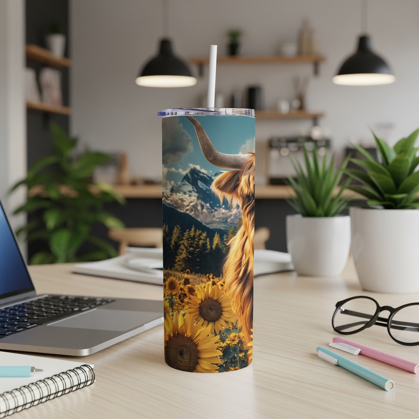 Highland cow in sunflower field with mountains, on a tumbler.