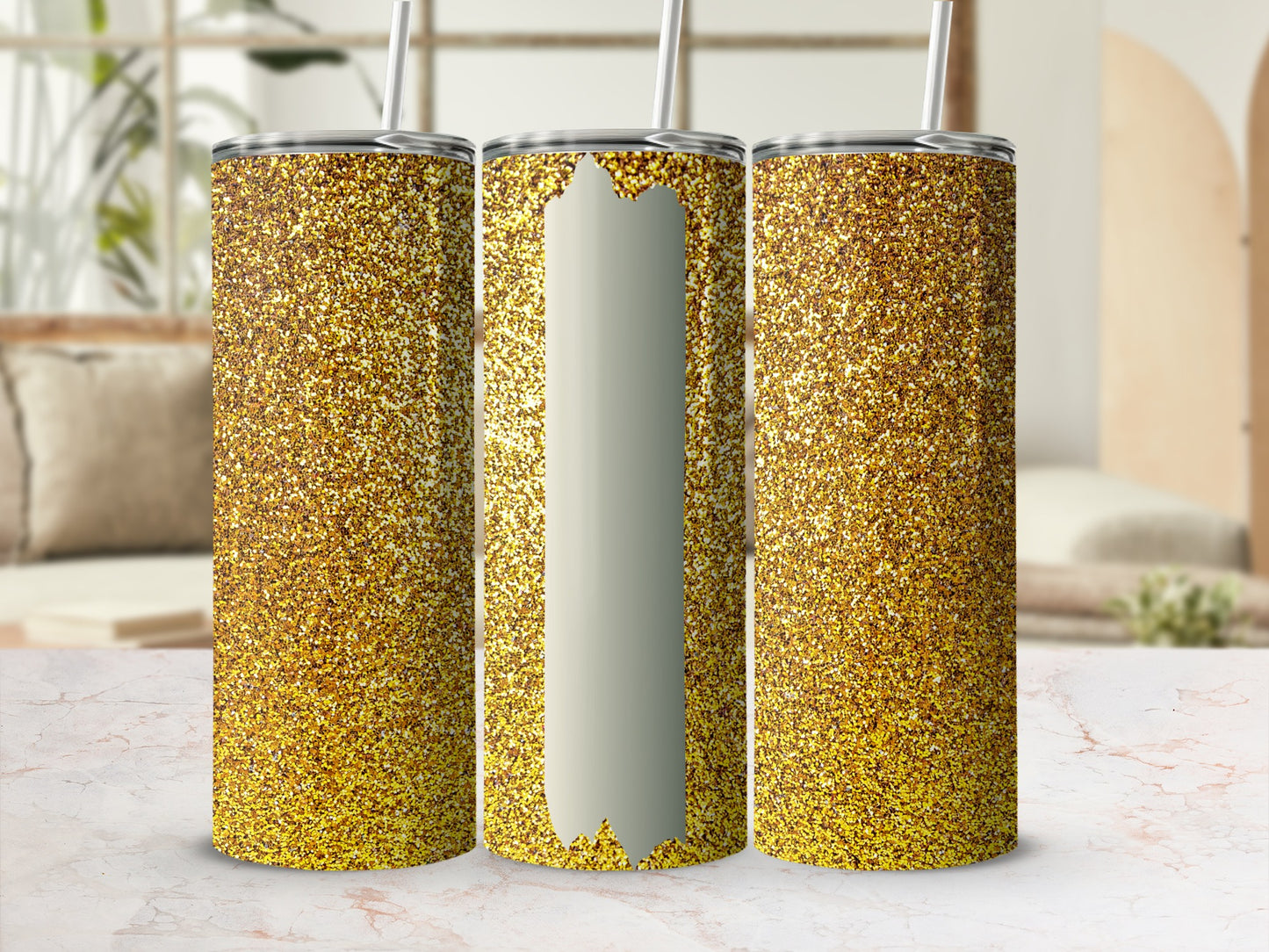 Three gold glitter tumblers with straws in a studio setting.