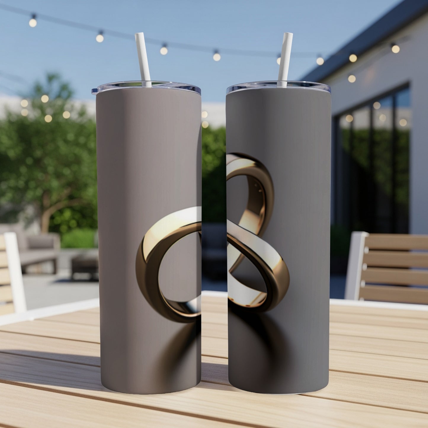 Two gray tumblers with a gold infinity symbol design on a wooden table.