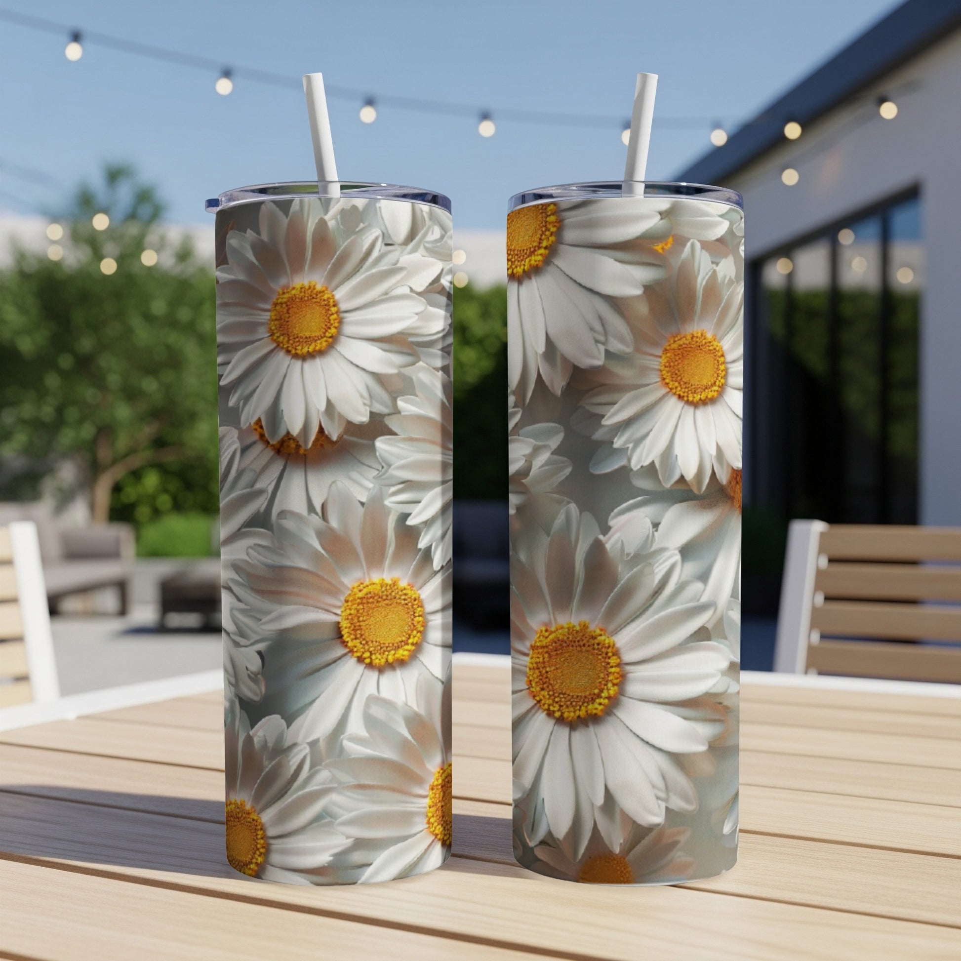 Two tumblers with a close-up daisy floral pattern sit on a table.